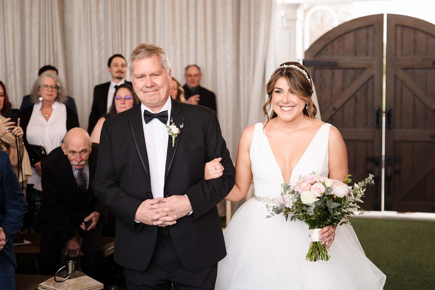 The bride is extremely excited as she is walked down the aisle by her father toward her soon to be husband.