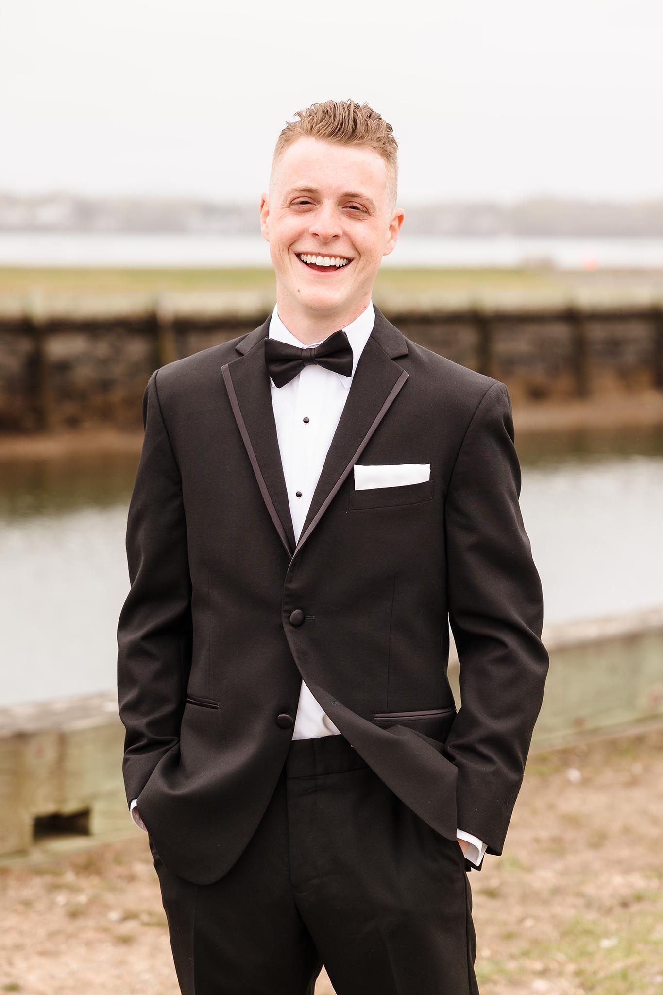 A formal portrait of a very happy groom on his wedding day.