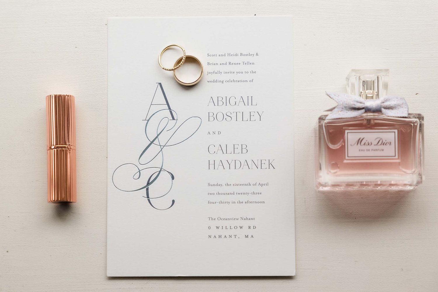 Here are some of the wedding day details including the wedding rings, invitation, and perfume.