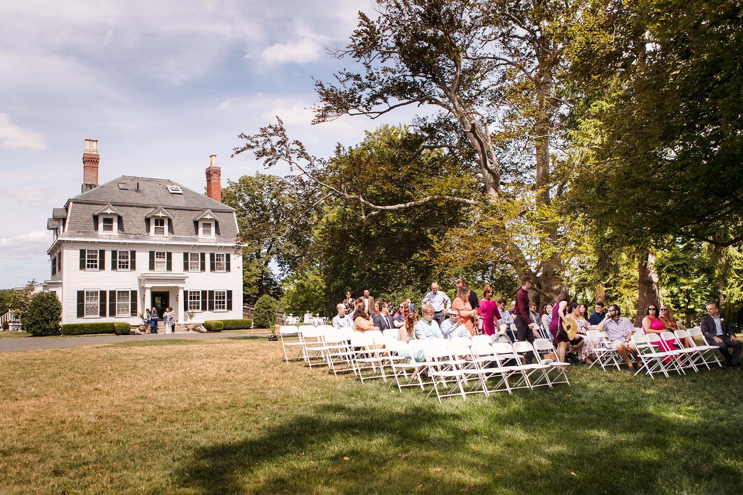 A  wedding ceremony begins on the lawn at Peirce Farm Witch Hill