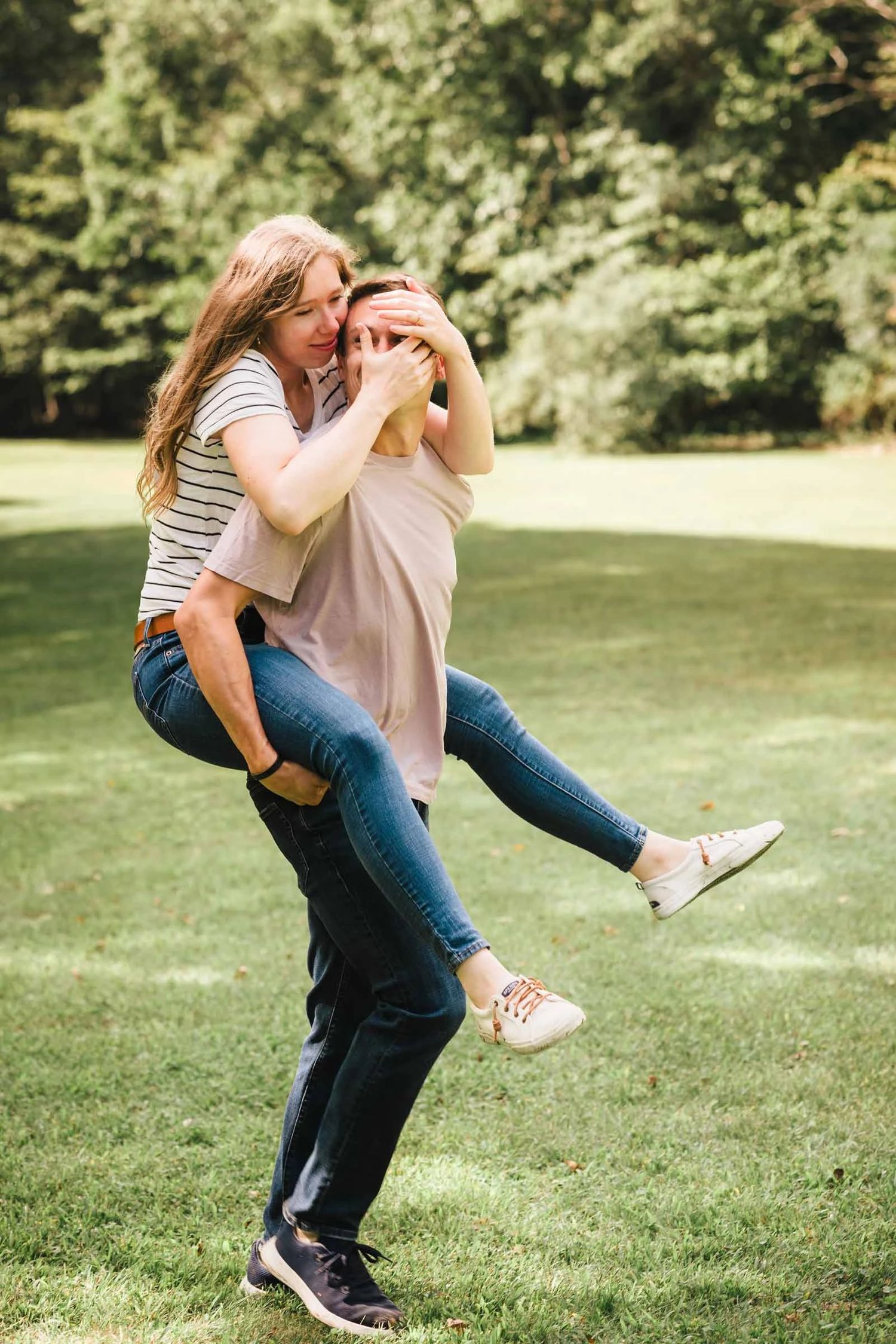 Engagement session at Borderland State Park: man lifts woman playfully off the ground in a joyful embrace outdoors