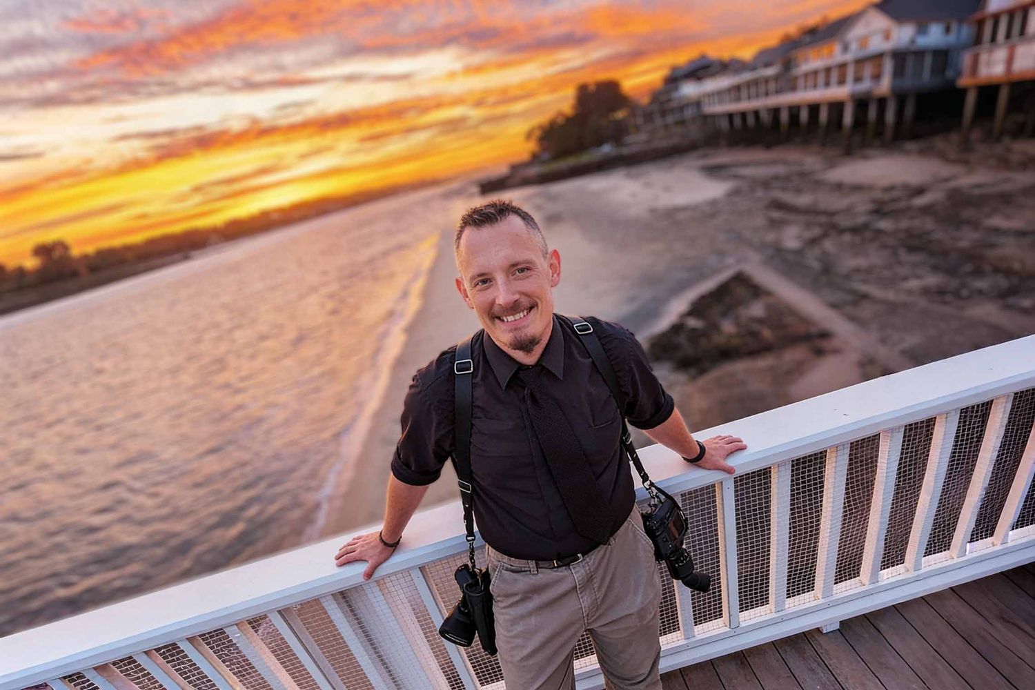Headshot of Boston Wedding Photographer Gregory Hitchcock, standing on a dock in Rockport with the warm sunset behind him.