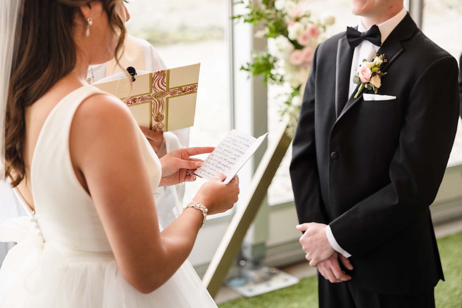 During the wedding ceremony the bride reads the vows she wrote from her homemade vow book.