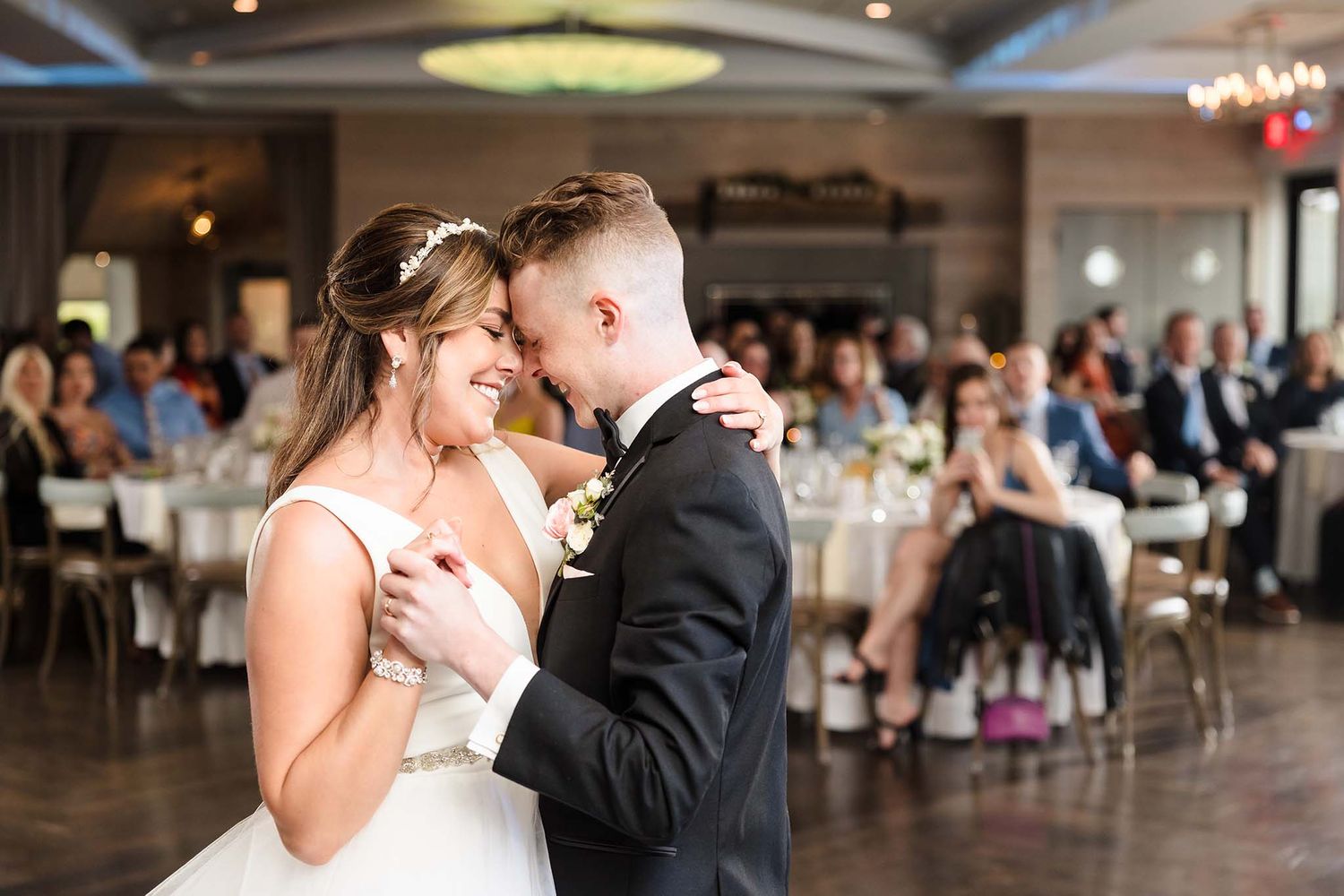 Wedding photography of the bride and groom at their reception enjoying their first dance.