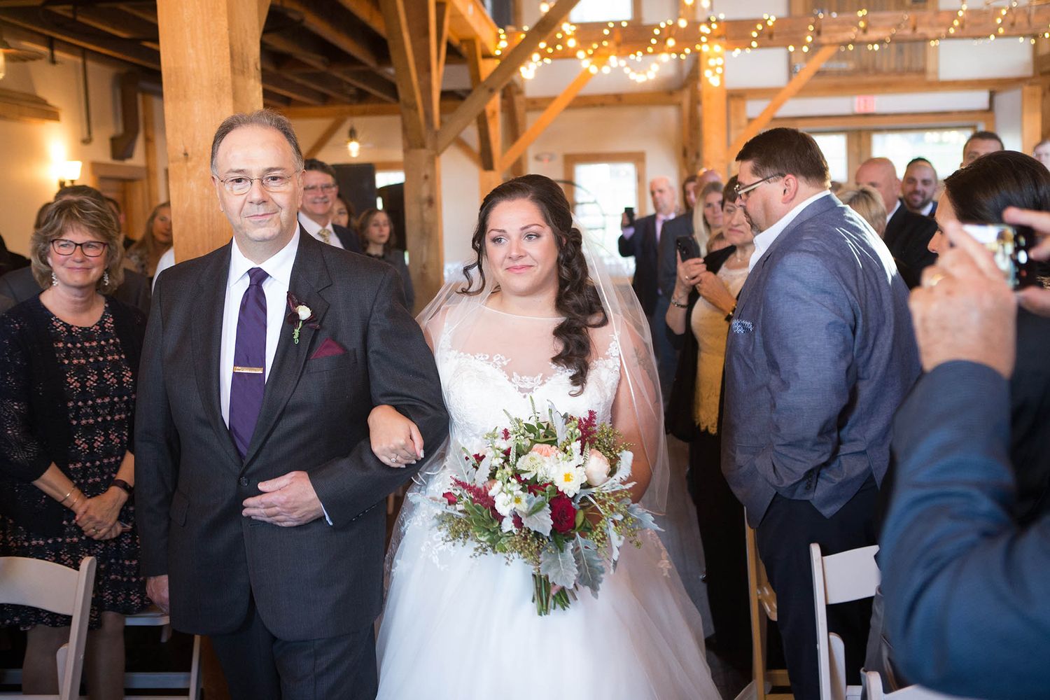 The bride and her father walk down the aisle during the wedding ceremony.