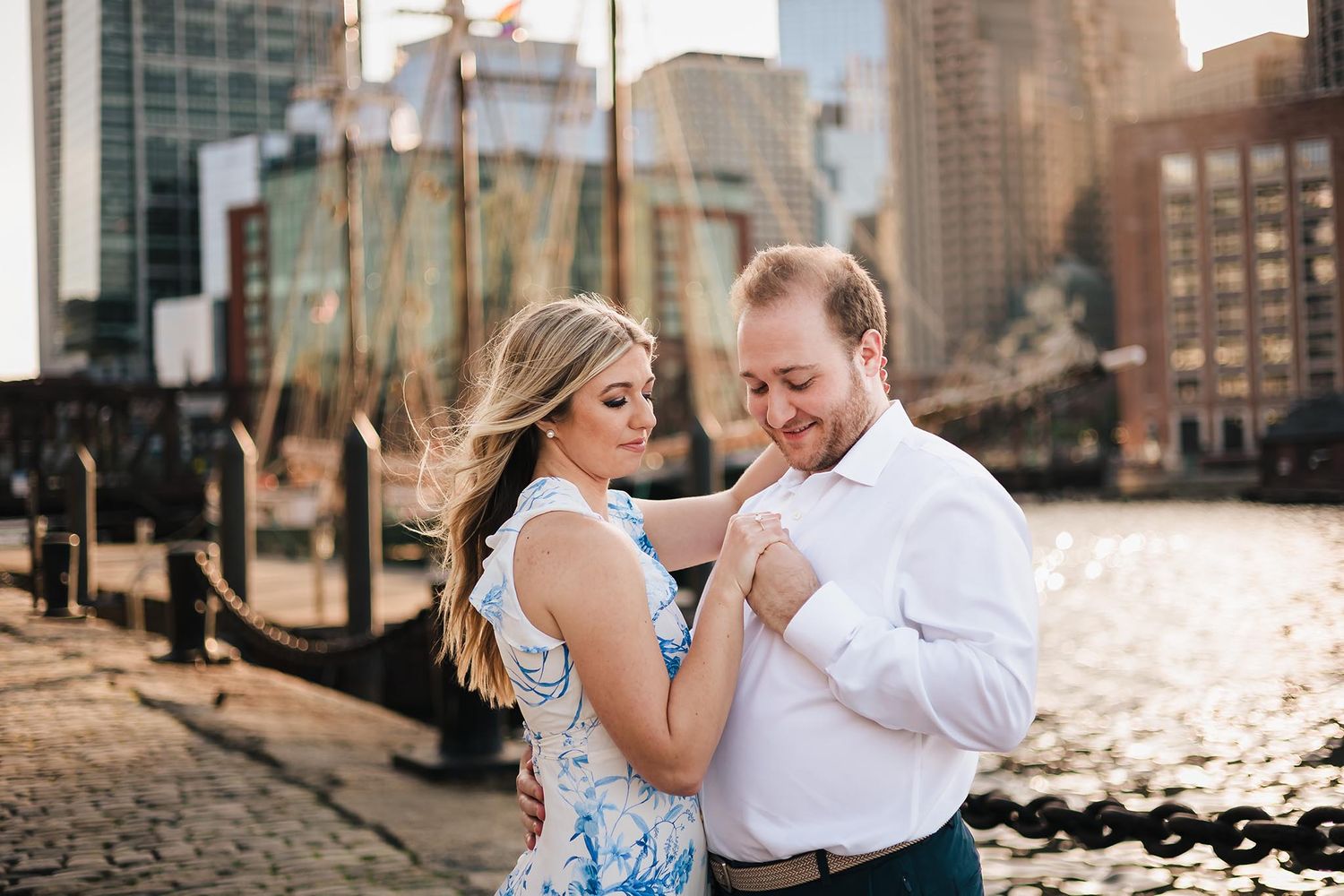 The bride and groom to be enjoy a quiet embrace during their engagement session at Fan Pier Park