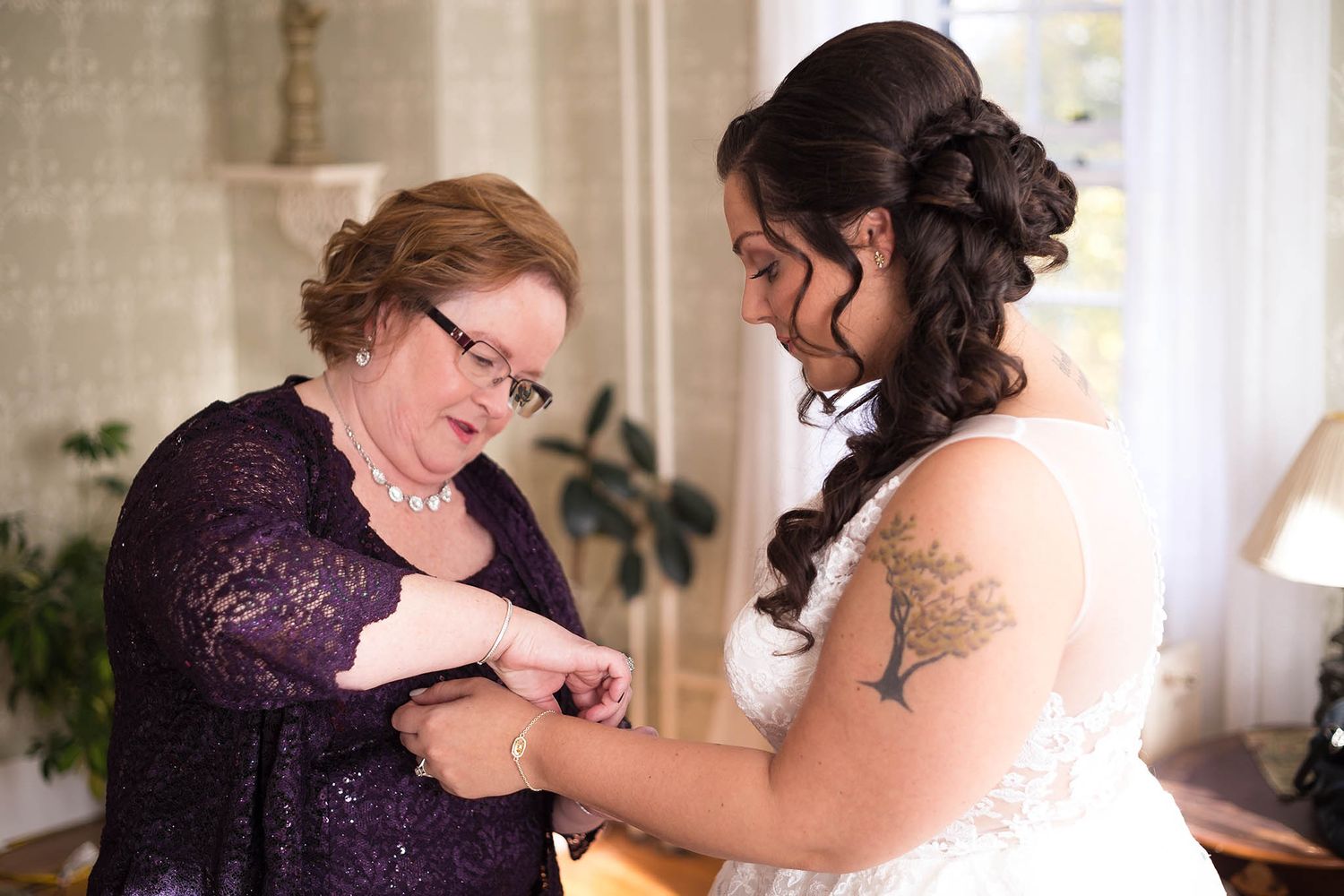 Bride's grandmother helps her with her finishing touches.