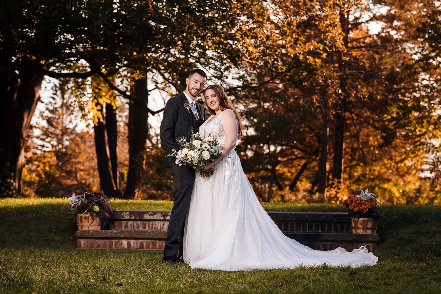 The bride and groom pose for a dramatic Formal portrait at sunset on the lawn of Peirce Farm Witch hill