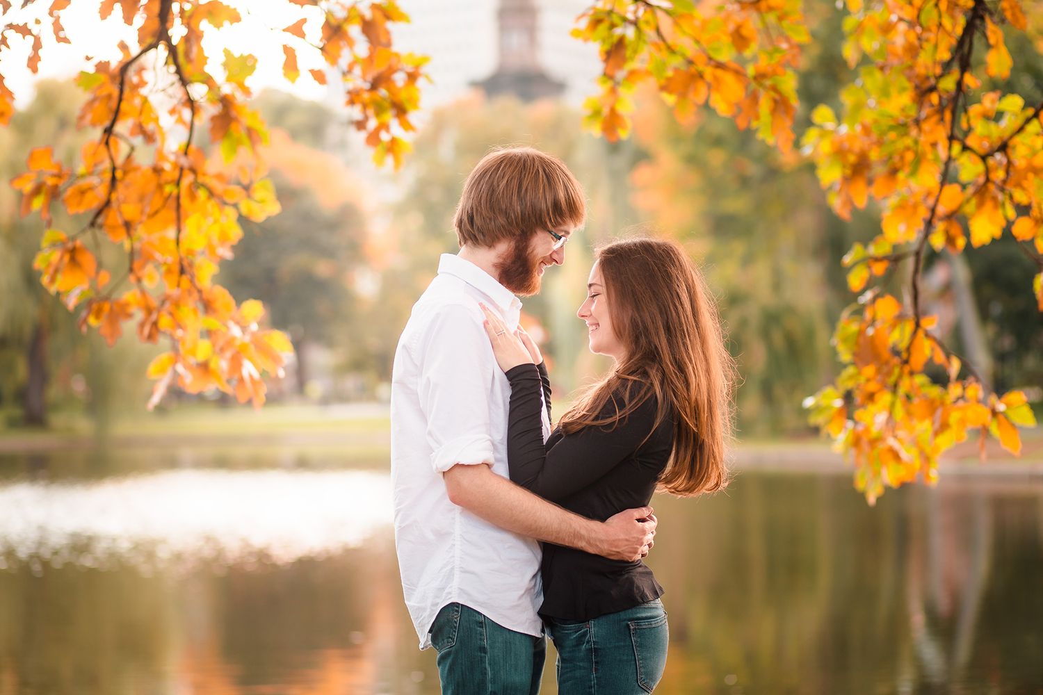The bride and groom give each other a tight hug during their engagement session at the Boston Public Garden
