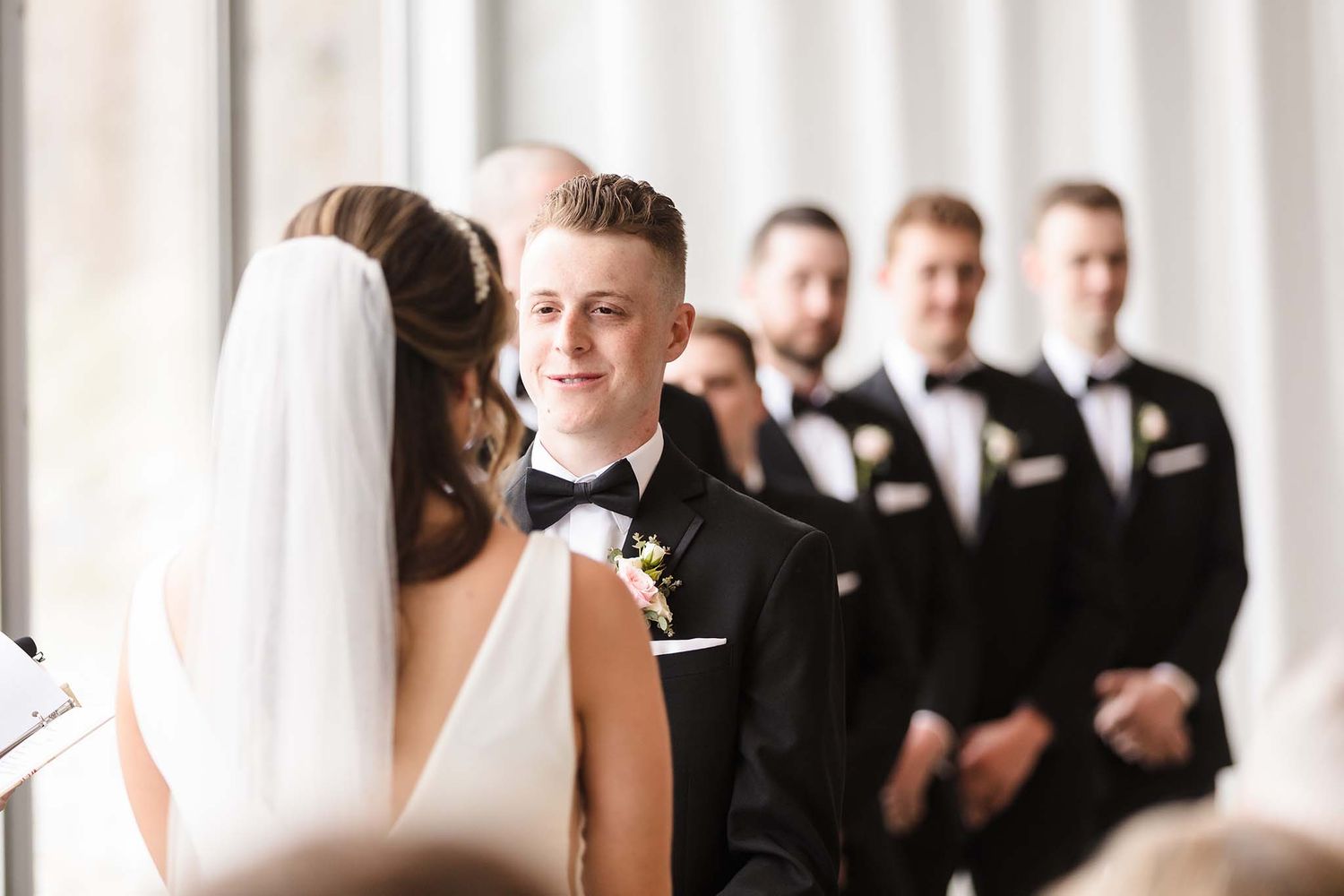 THe groom smiles as he looks into the eyes of the bride.
