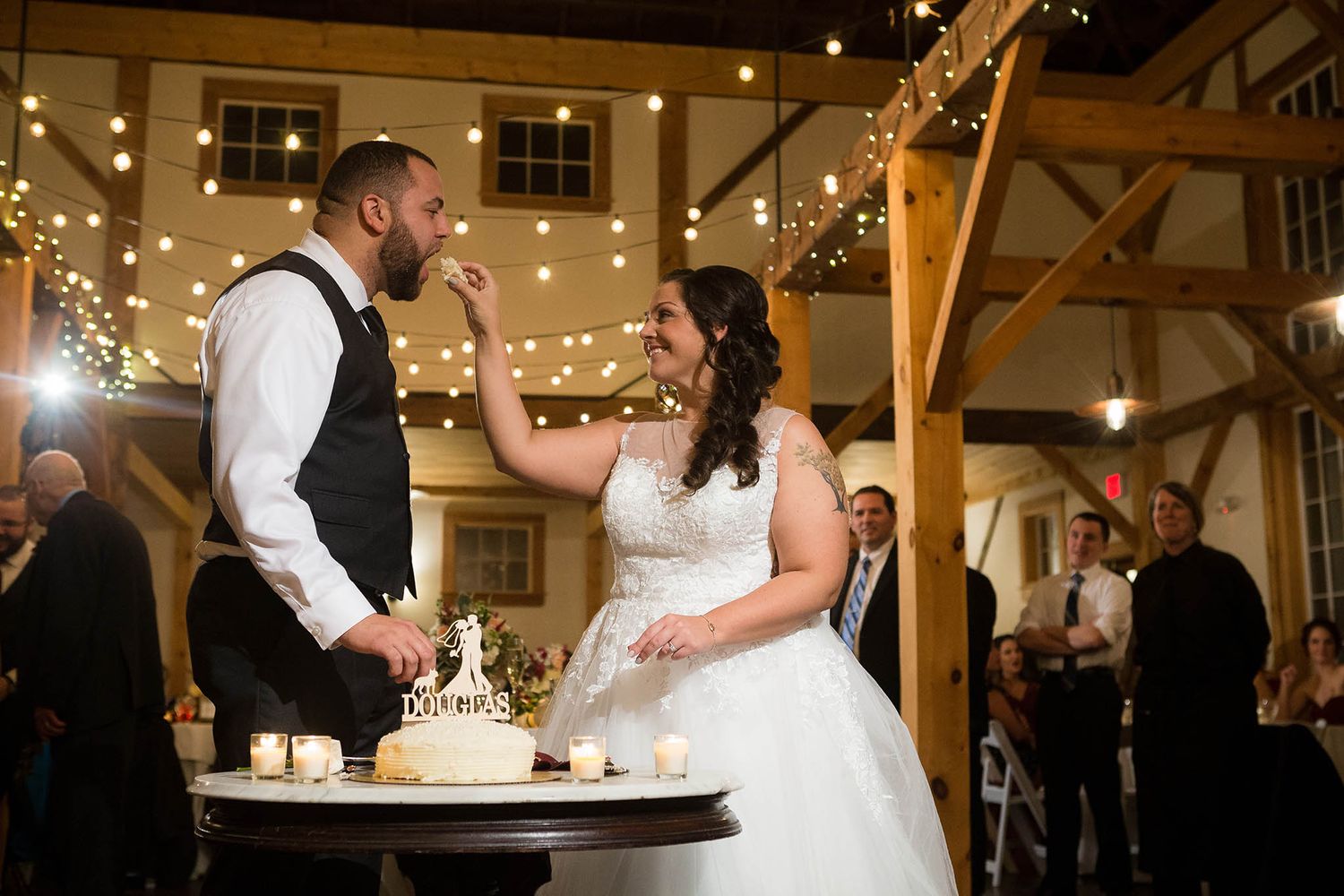 The bride and groom cut their wedding cake in the barn at Peirce Farm.