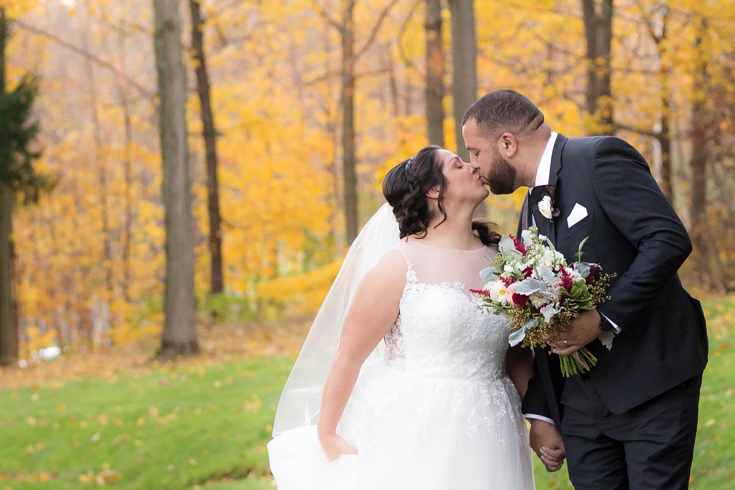 The bride and groom share a quick kiss on their wedding day at Peirce Farm.