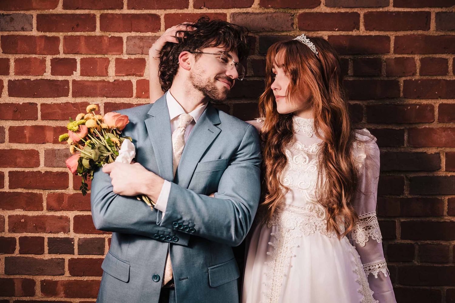 Bride and groom gaze at each other during their elopement in Boston's North End Neighborhood with groom holding yellow flowers