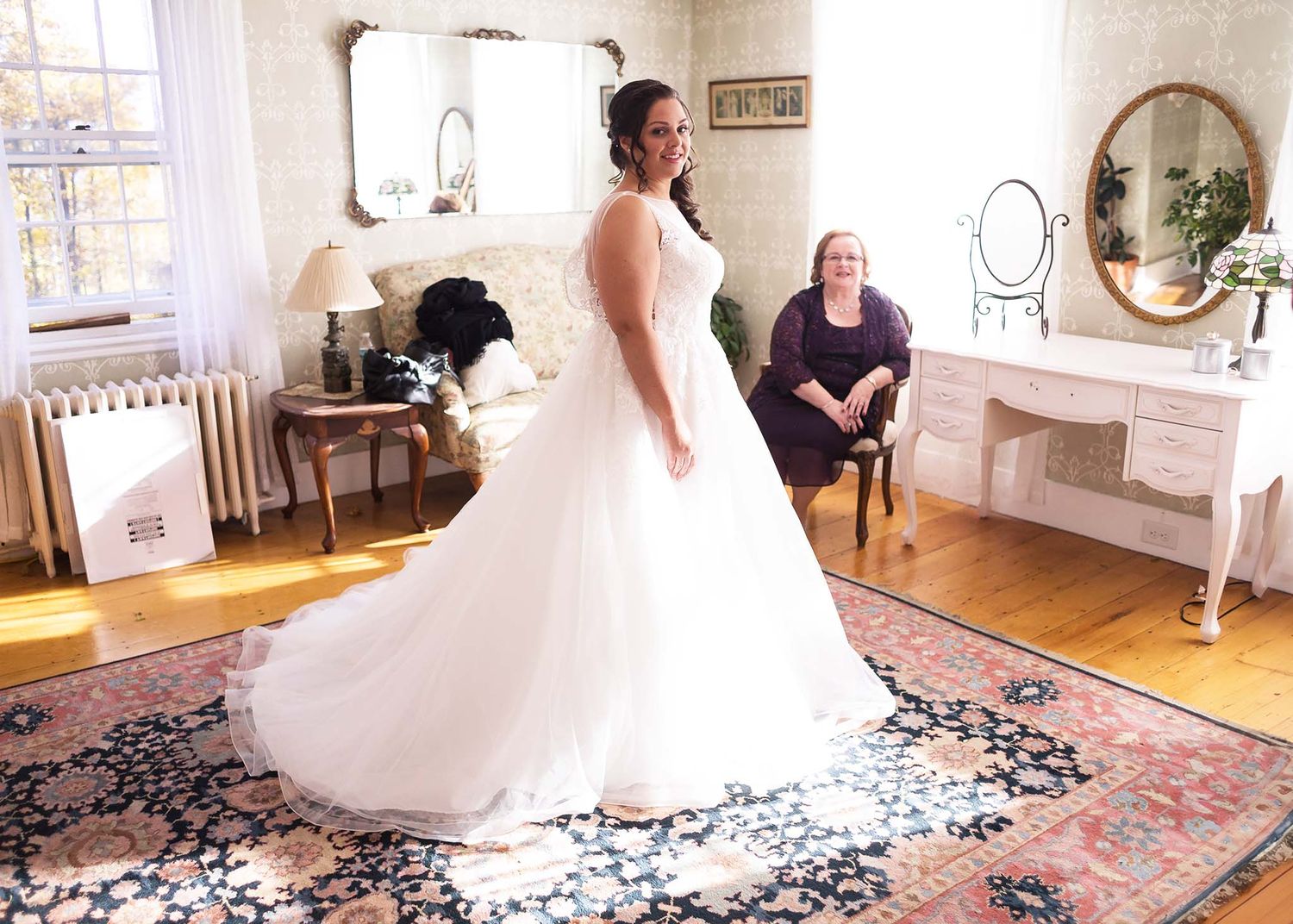 The bride puts on her wedding dress with her mother at Peirce Farm.