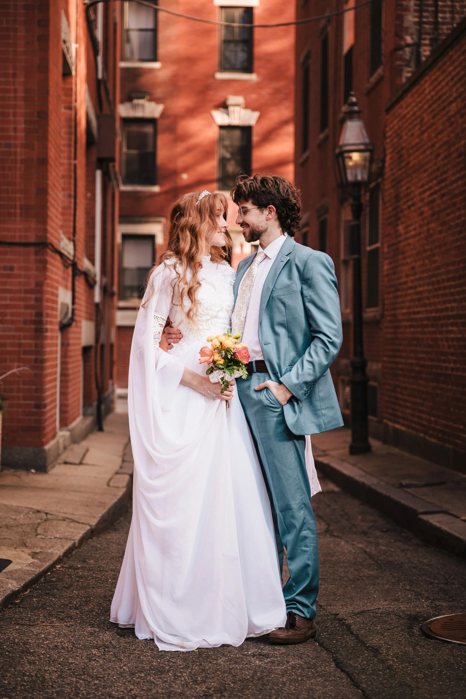 Bride and groom kiss in a brick alley near Boston's North End neighborhood during their elopement,