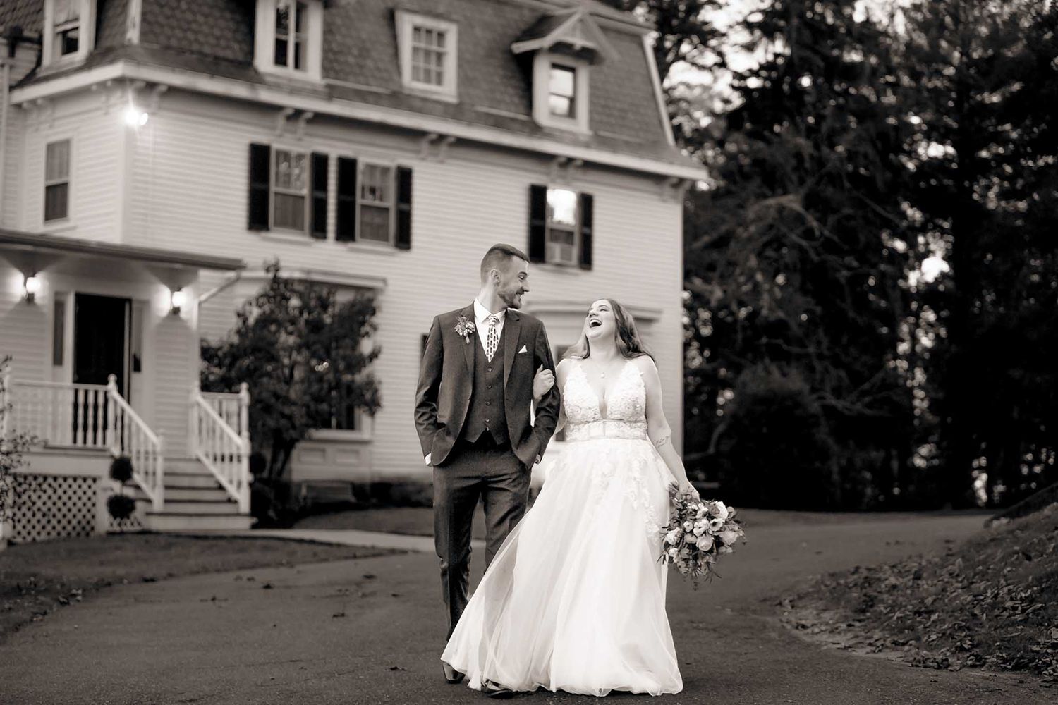The bride and groom share a laugh as they walk down the hill toward their wedding reception.