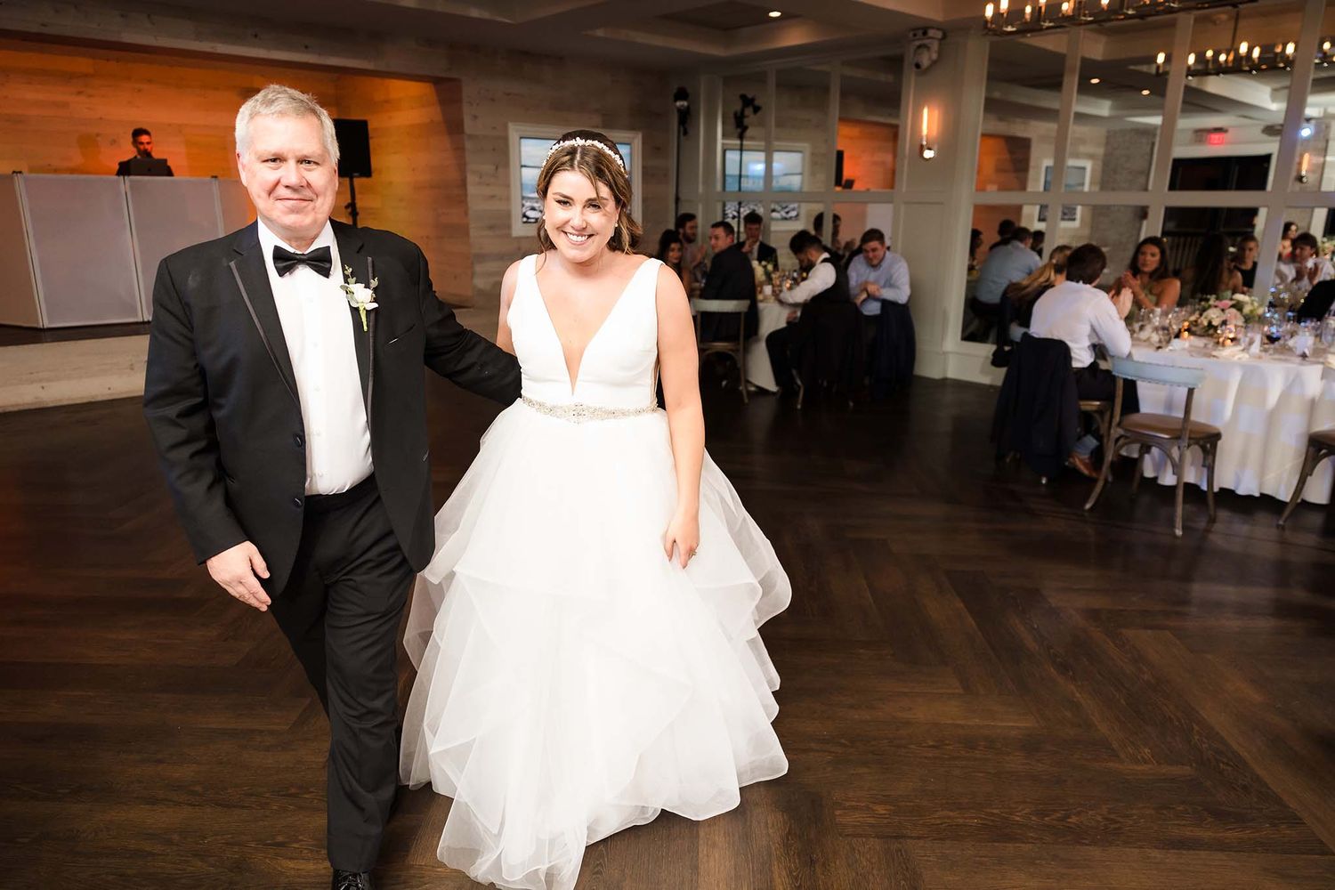 The father of the bride and bride walk onto the dance floor for their dance.