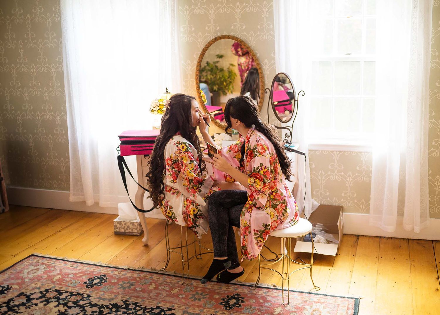 The bride's sister helps her with her makeup at Peirce Farm Witch hill.