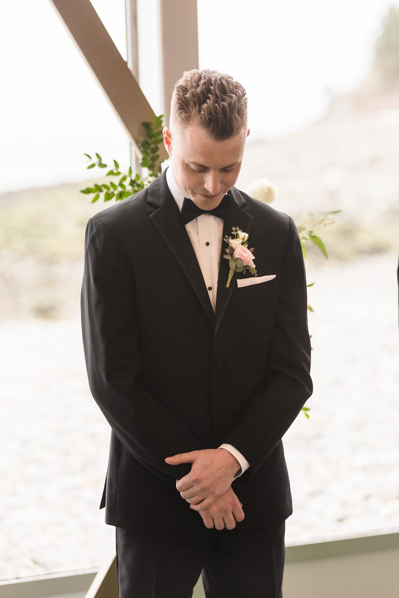 The groom has a private reflective moment right before he sees the bride in her dress for the first time.