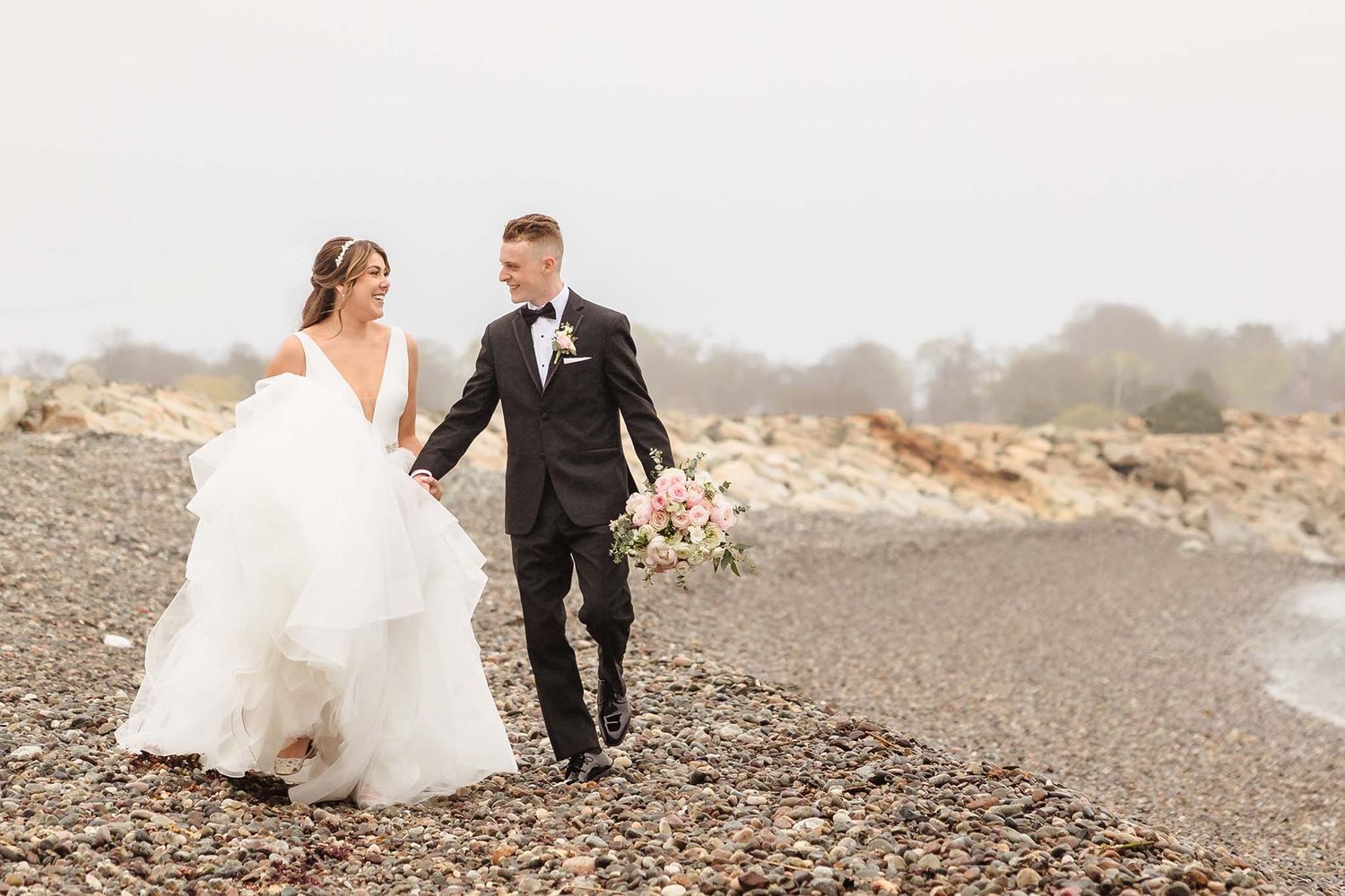 The newly wed couple enjoy a romantic walk on the beach outside the oceanview of Nahant.
