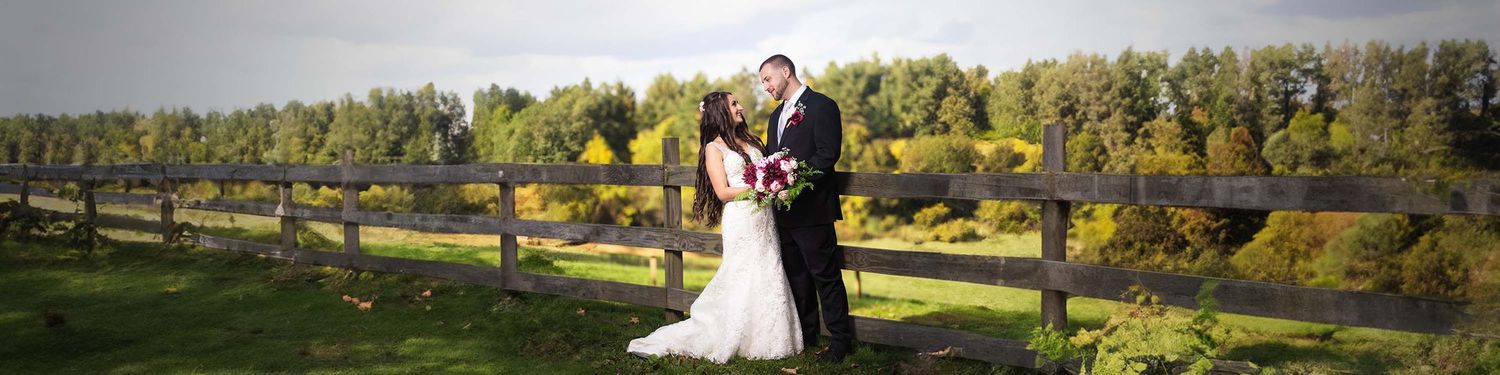 The bride and groom pose for a romantic portrait in front of the pasture at Peirce Farm witch hill.