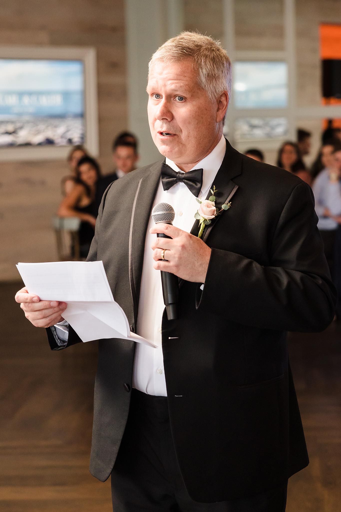 The father of the bride gives a passionate speech to the newly wed couple at the wedding reception.