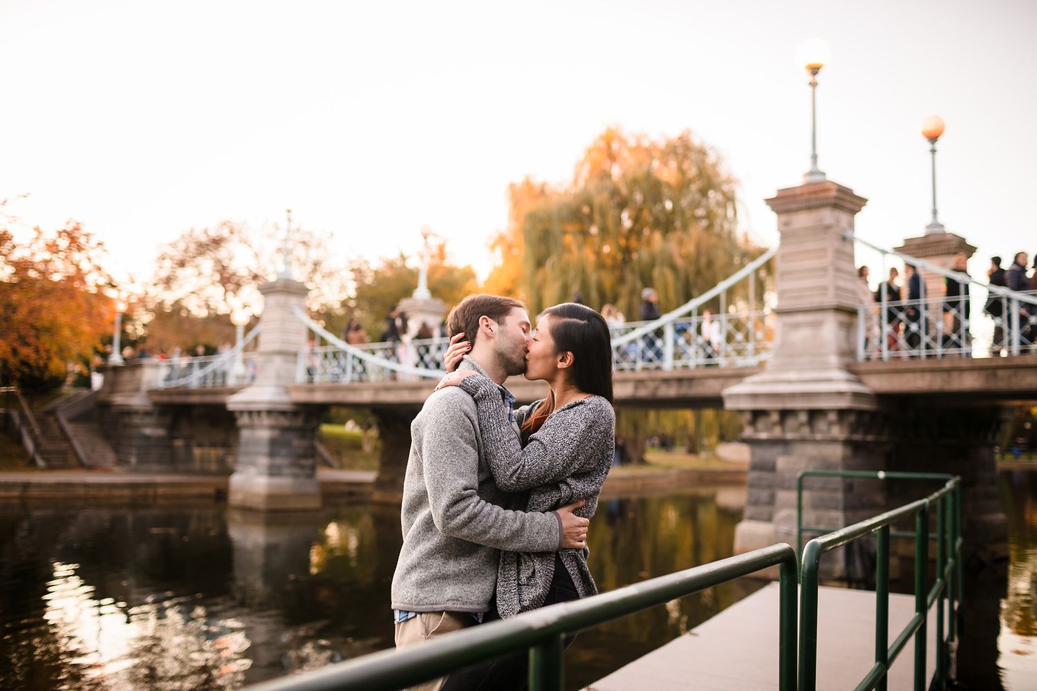 The bride and groom share a passionate kiss front of the Foot Bridge in the Boston Public Garden