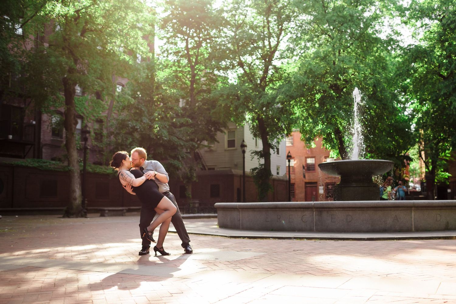 A loving engaged couple strike a dramatic tango pose in the park while on their engagement session.