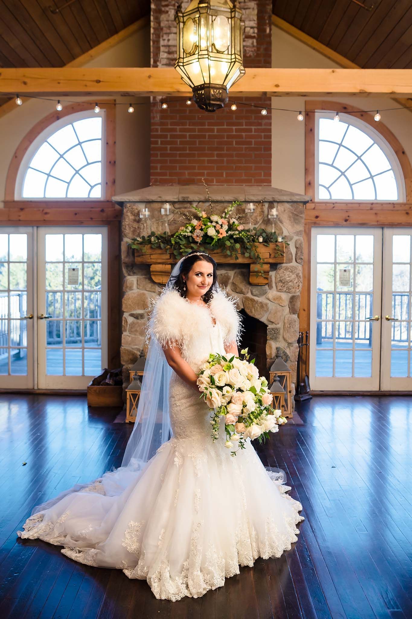 The bride shows off a striking dress in their formal portrait inside the Barn at Peirce Farm