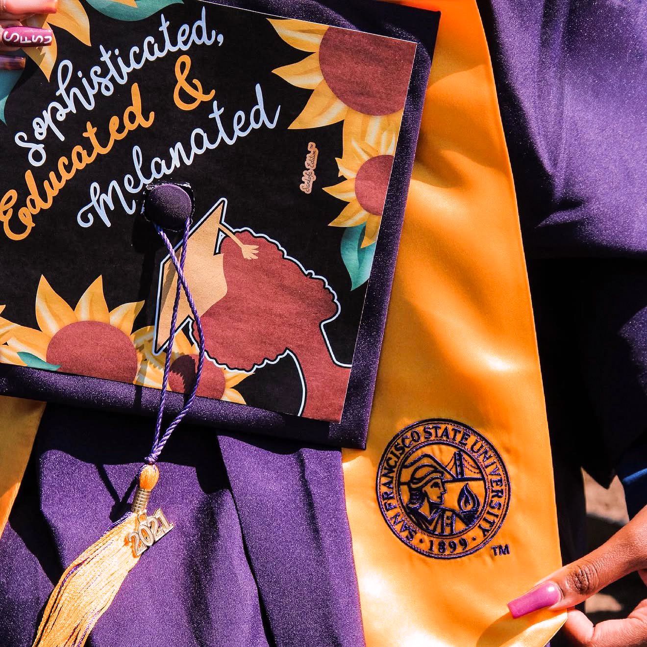 Graduation cap decorated with sunflowers reading Sophisticated, Educated & Melanated beside an orange San Francisco State University sash.