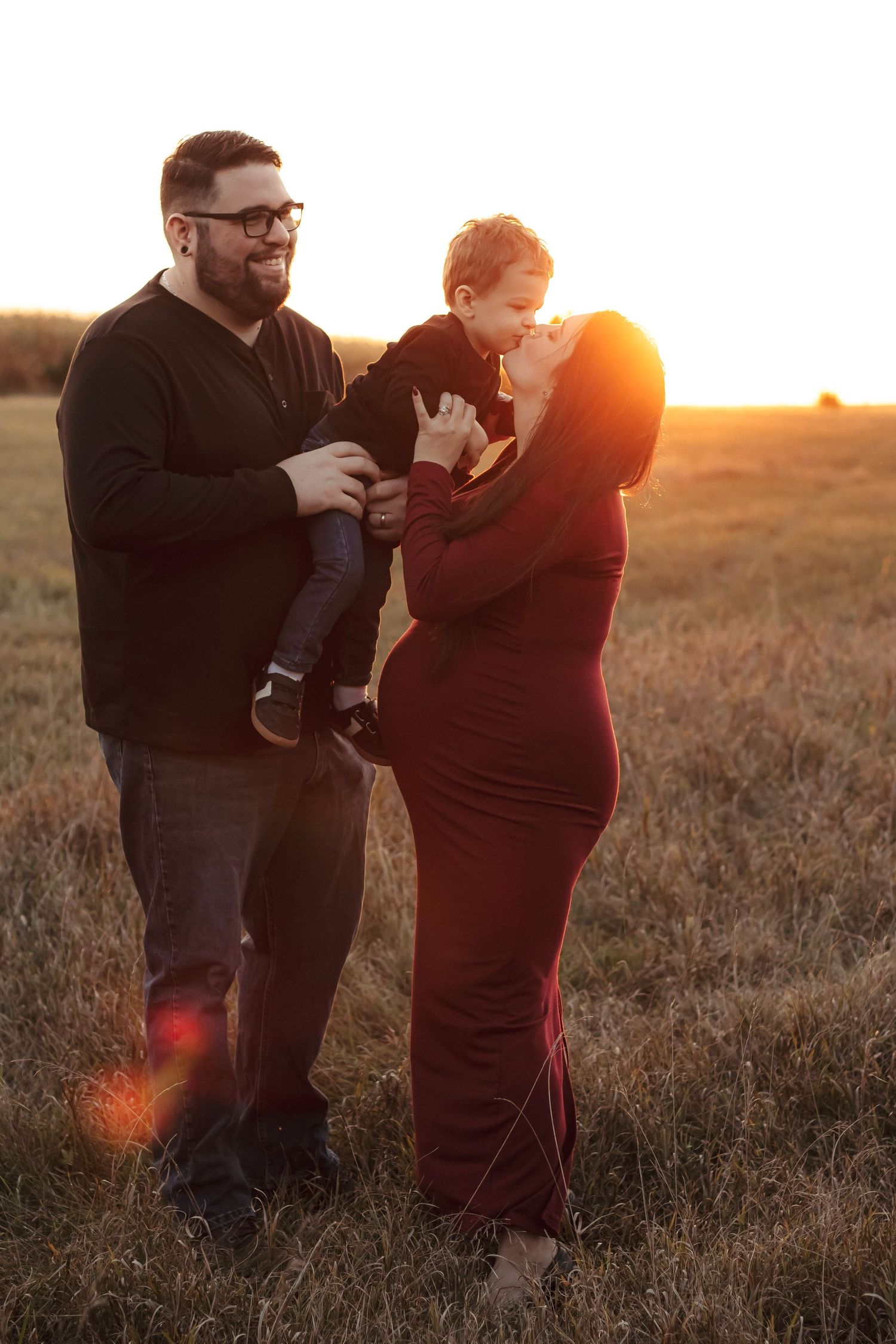 Mom kissing her child during a golden hour maternity photography session