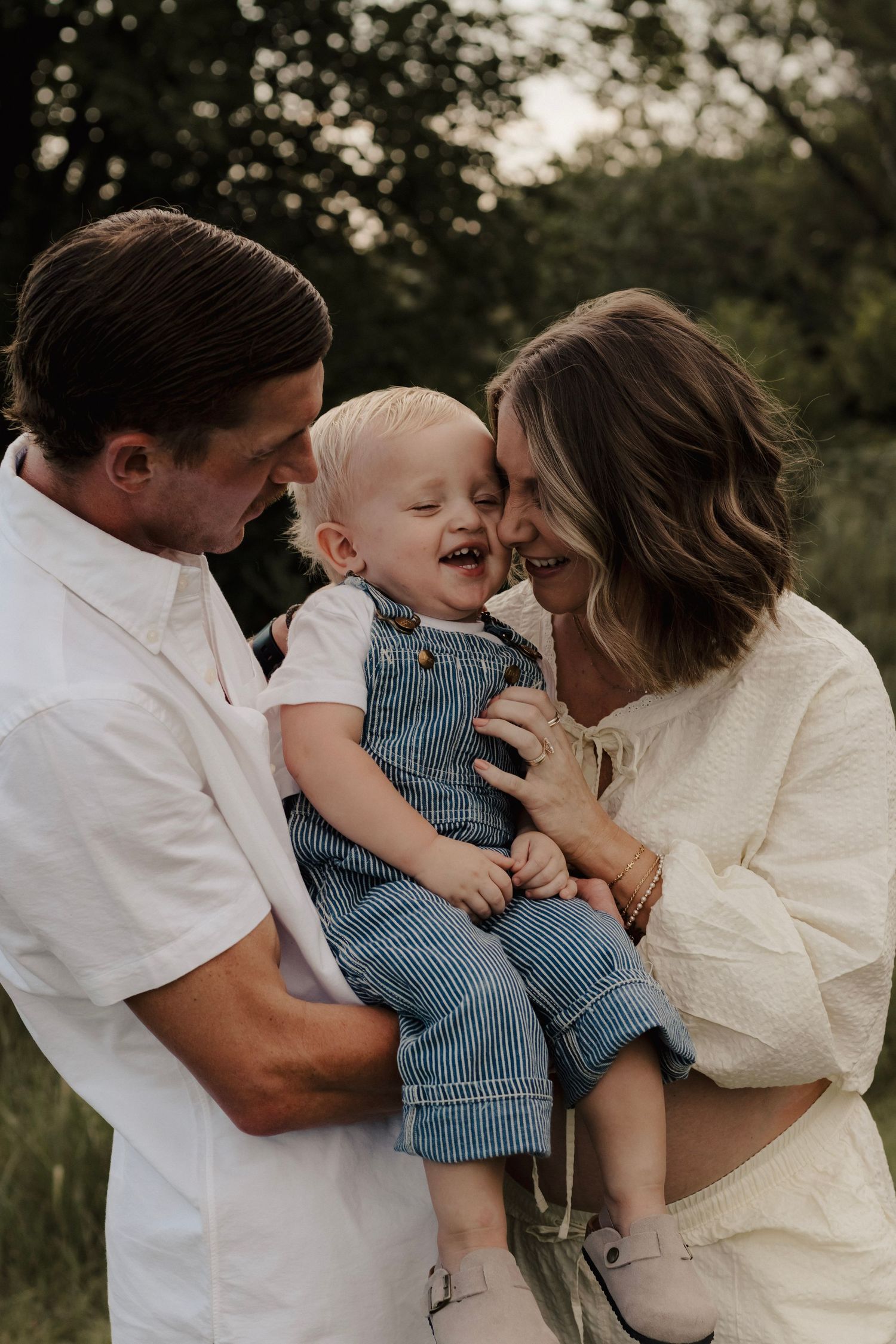 Family laughing with their toddler during an outdoor photo session