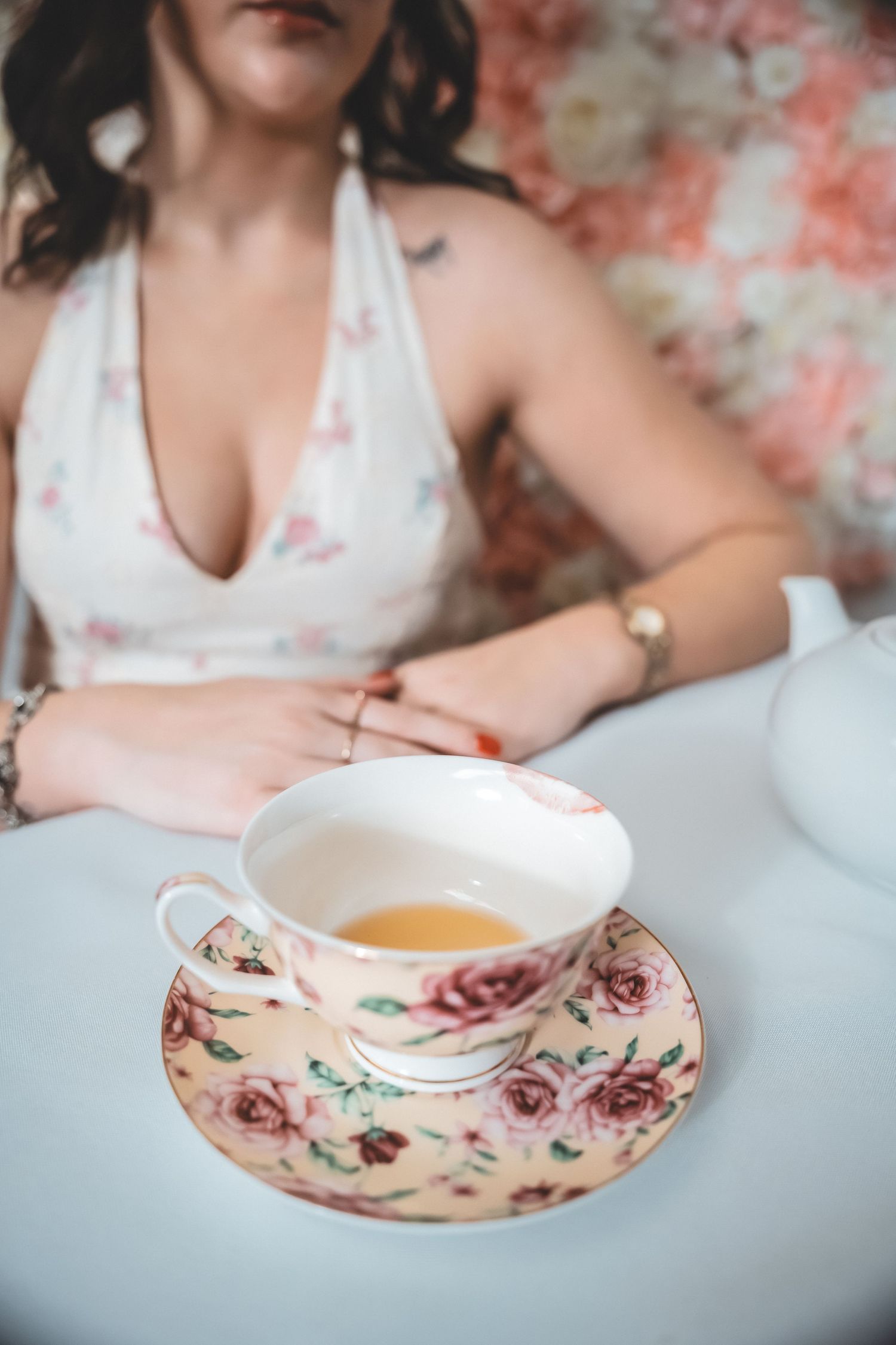 A delicate pink floral teacup and saucer set photographed in a series of dreamy, soft-focus compositions.