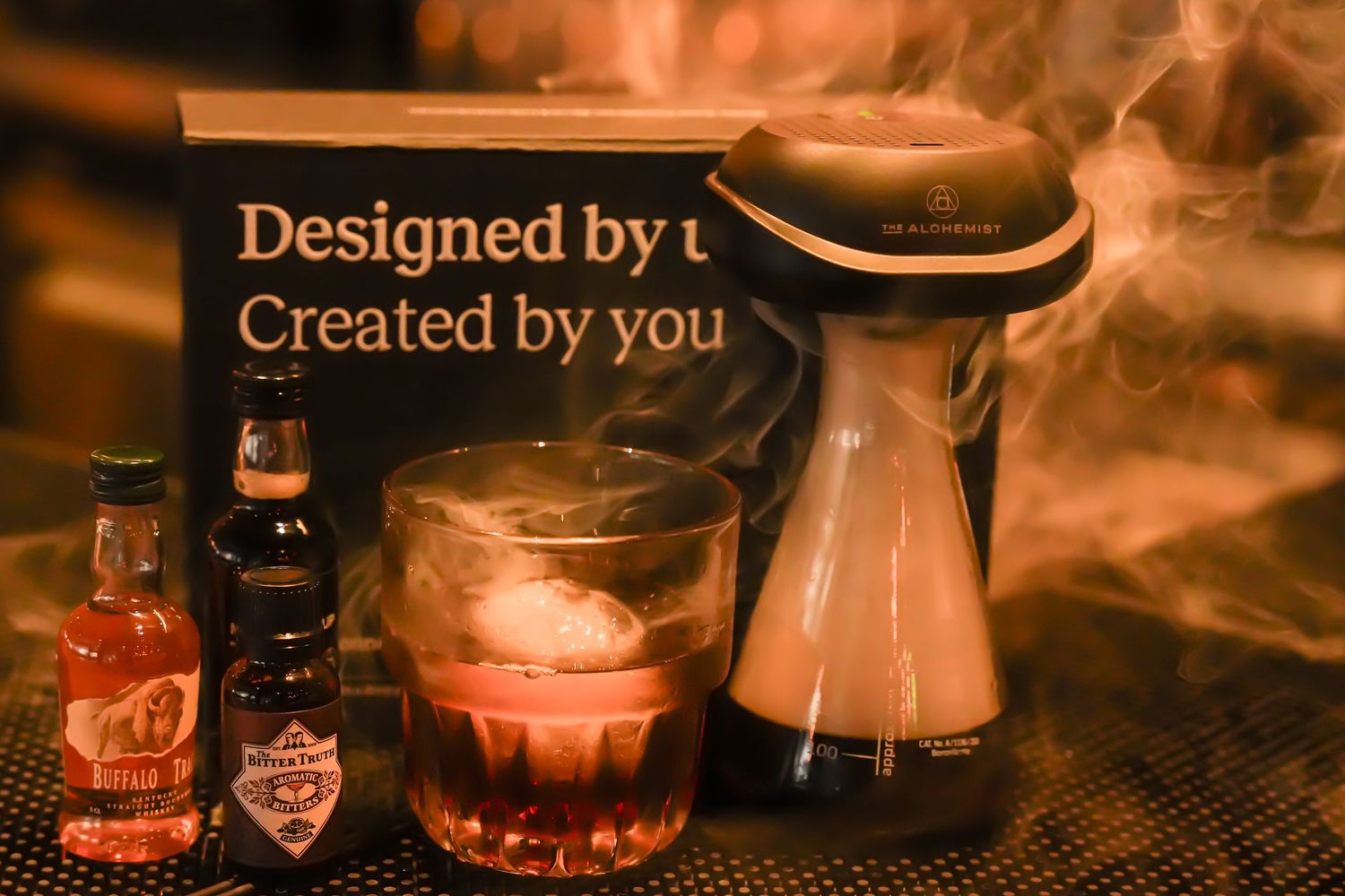 Smoky craft cocktail display with Old Fashioned ingredients and designed by us signage.