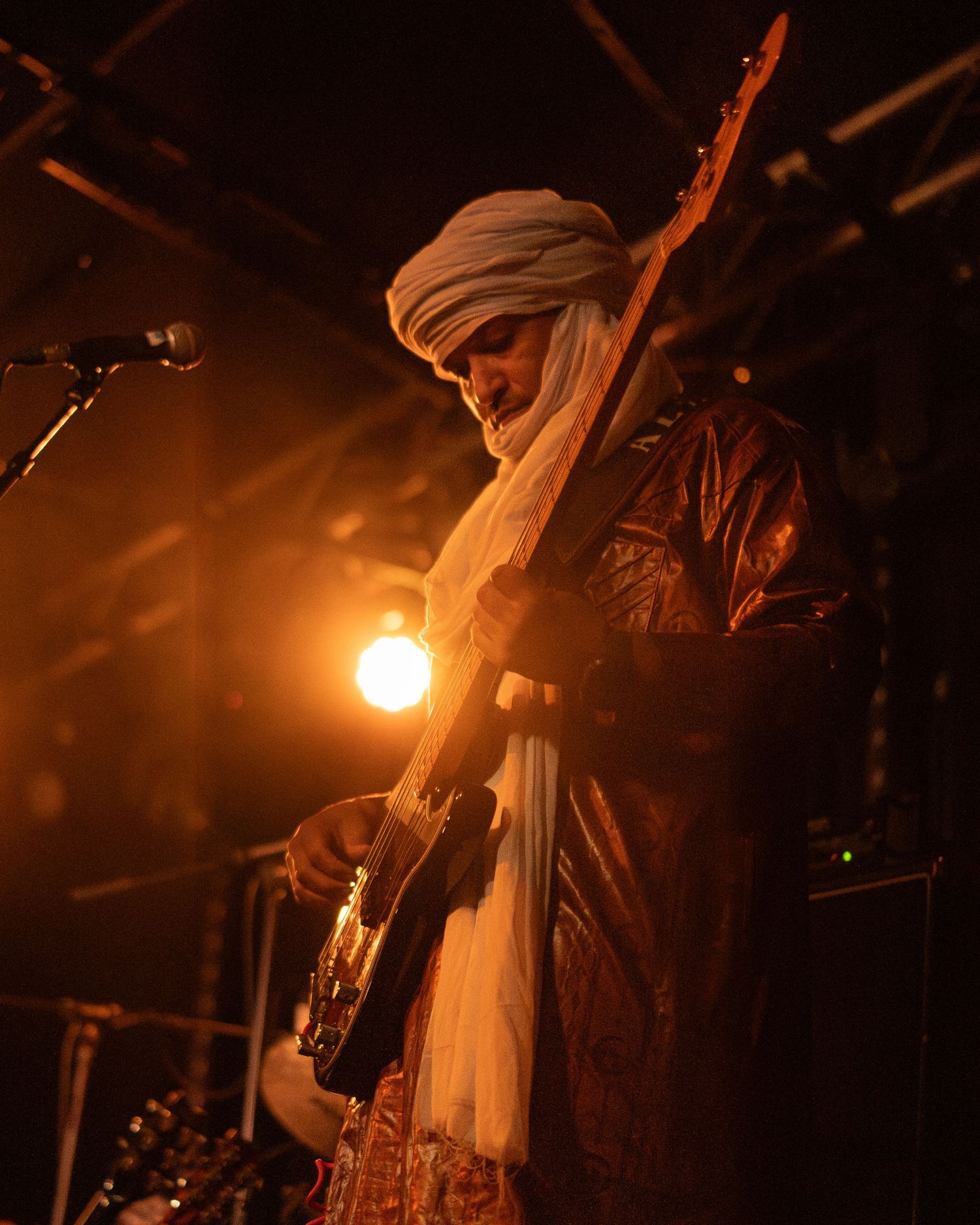 Tamikrest bassist performing under warm stage lighting at Belgrave Music Hall in Leeds