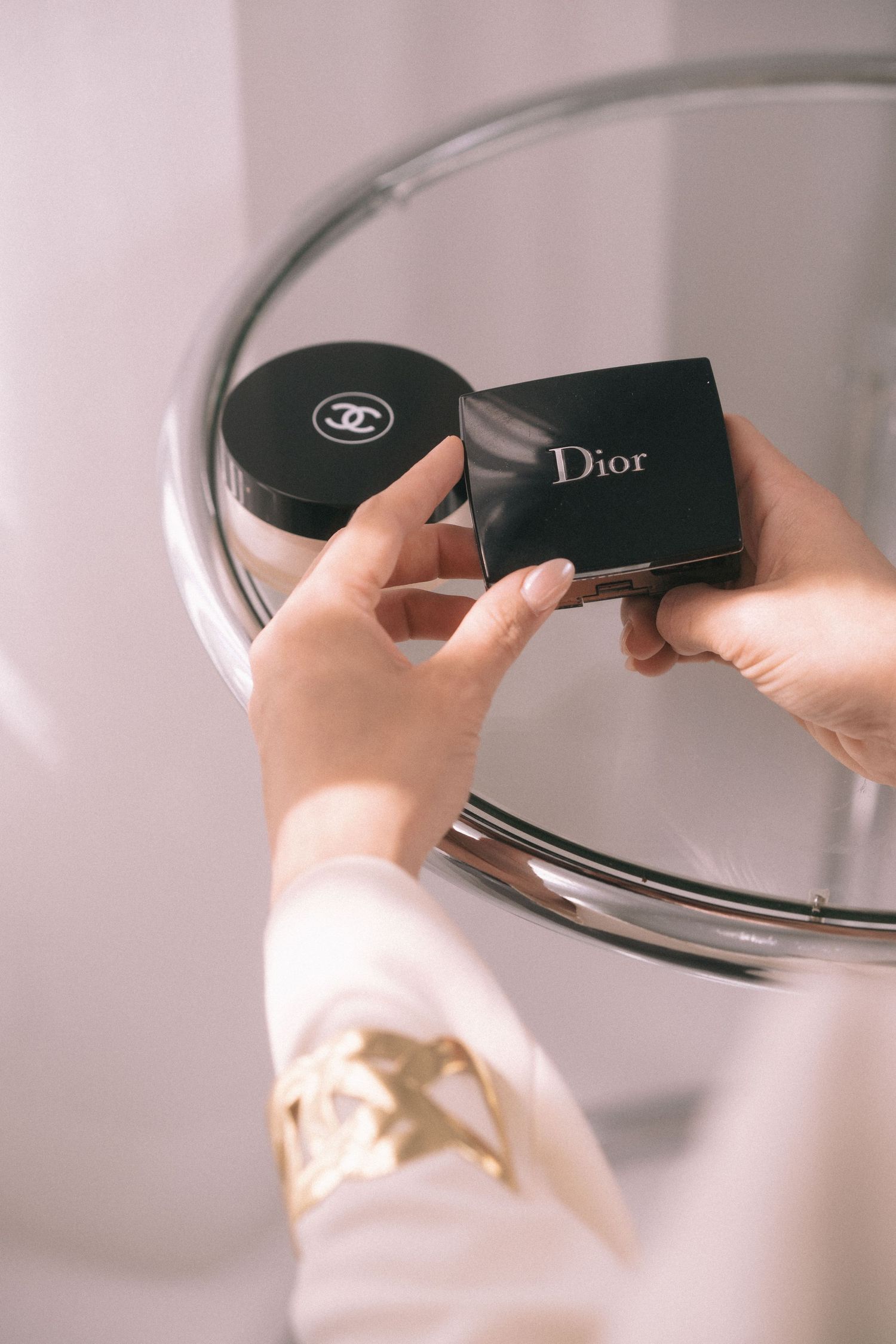Storytelling brand imagery in branding photography sessions captures hands holding Chanel and Dior luxury makeup products.