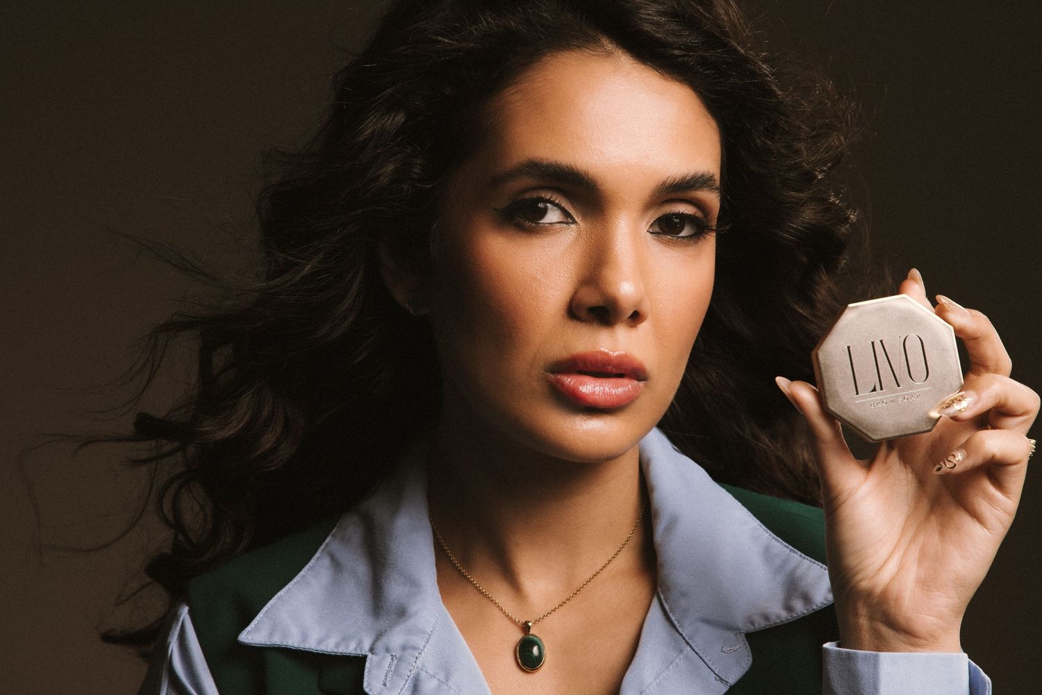 Professional photo of a makeup artist holding her product, showcasing branding photography sessions and high-converting brand photography.