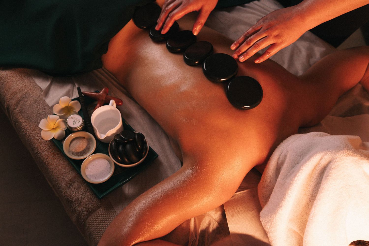 Storytelling brand imagery in branding photography sessions captures a top view of a hot stone massage treatment at a spa.