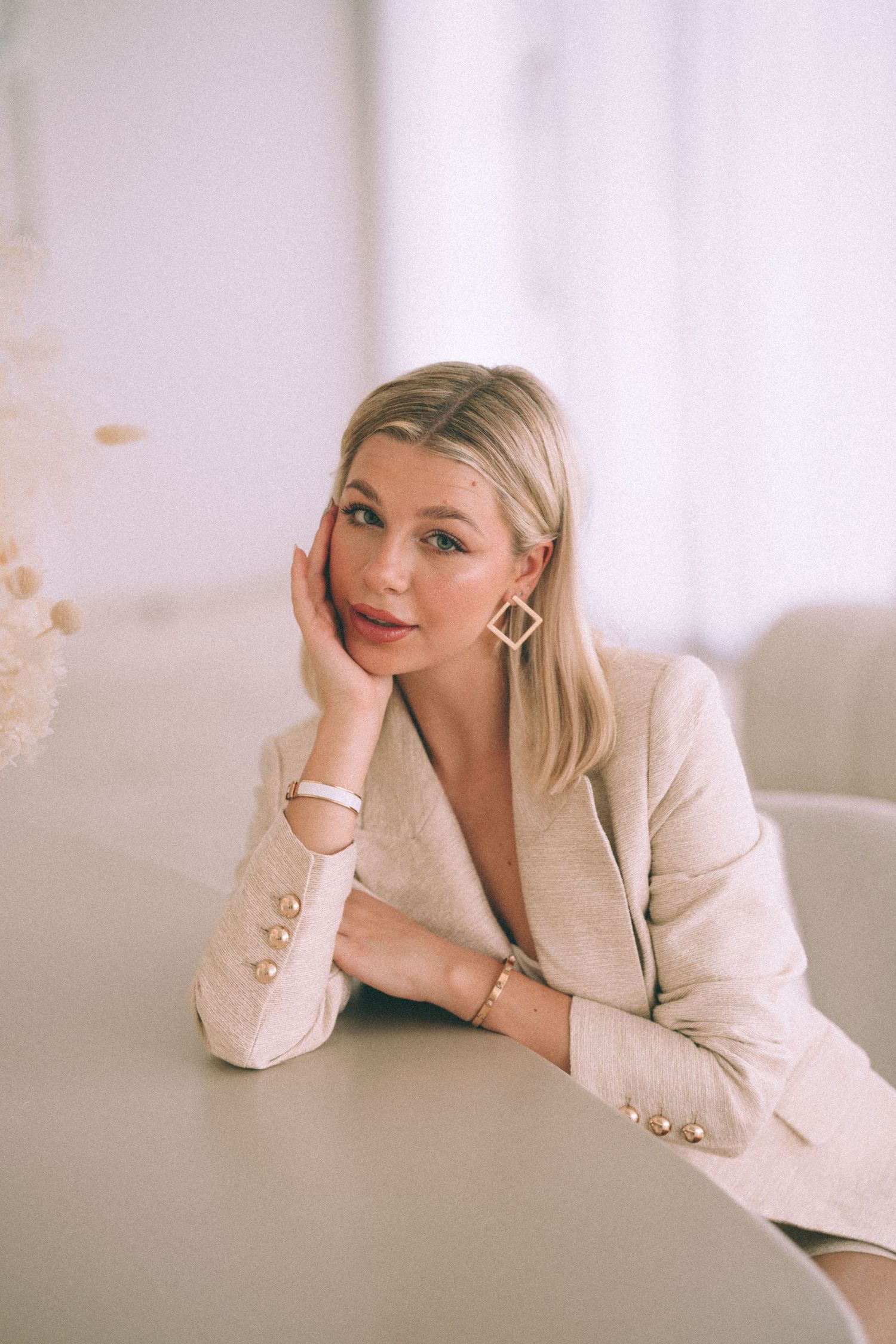 Branding Photography Sessions capture an entrepreneur in a cream blazer, wearing diamond earrings and neutral makeup.