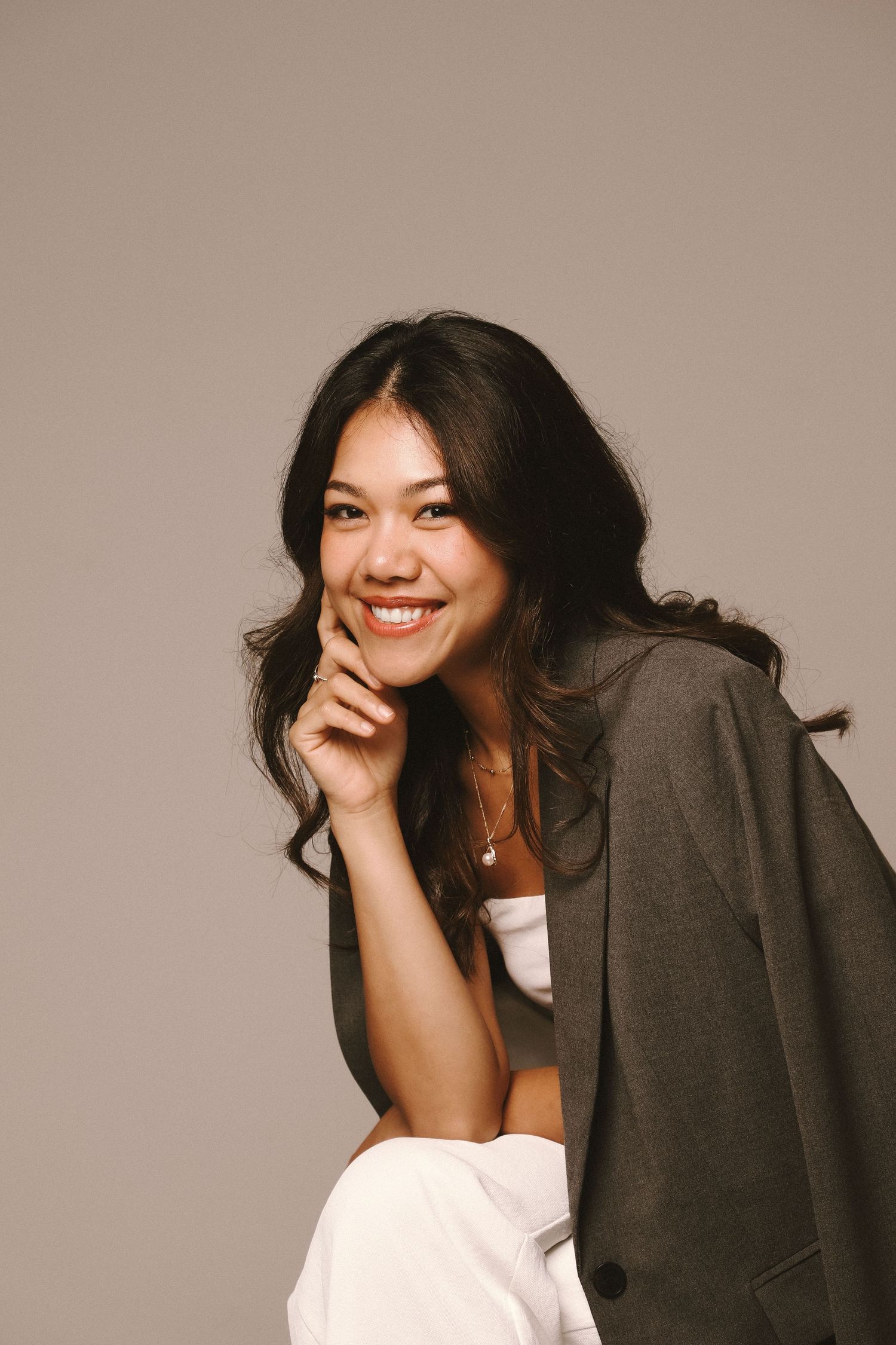 Branding Photography Sessions capture an entrepreneur with dark wavy hair, a black sleeveless top, and a white skirt.