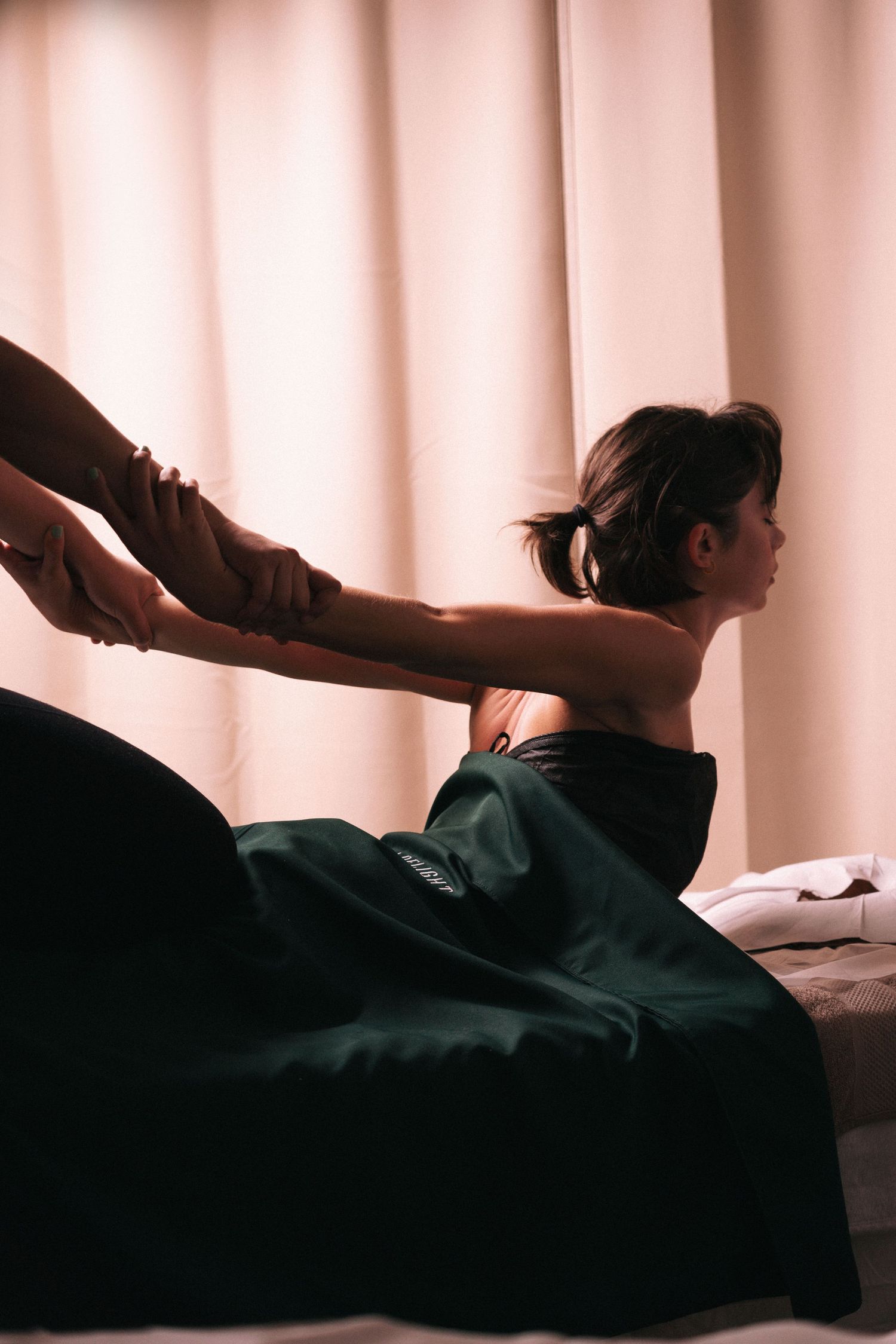 Storytelling brand imagery in branding photography sessions captures a person receiving a relaxing massage on a white draped bed.