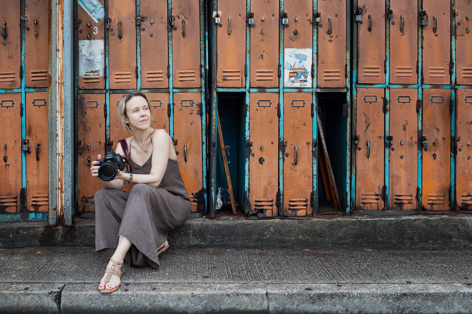 Person sitting casually in front of vintage orange metal lockers.