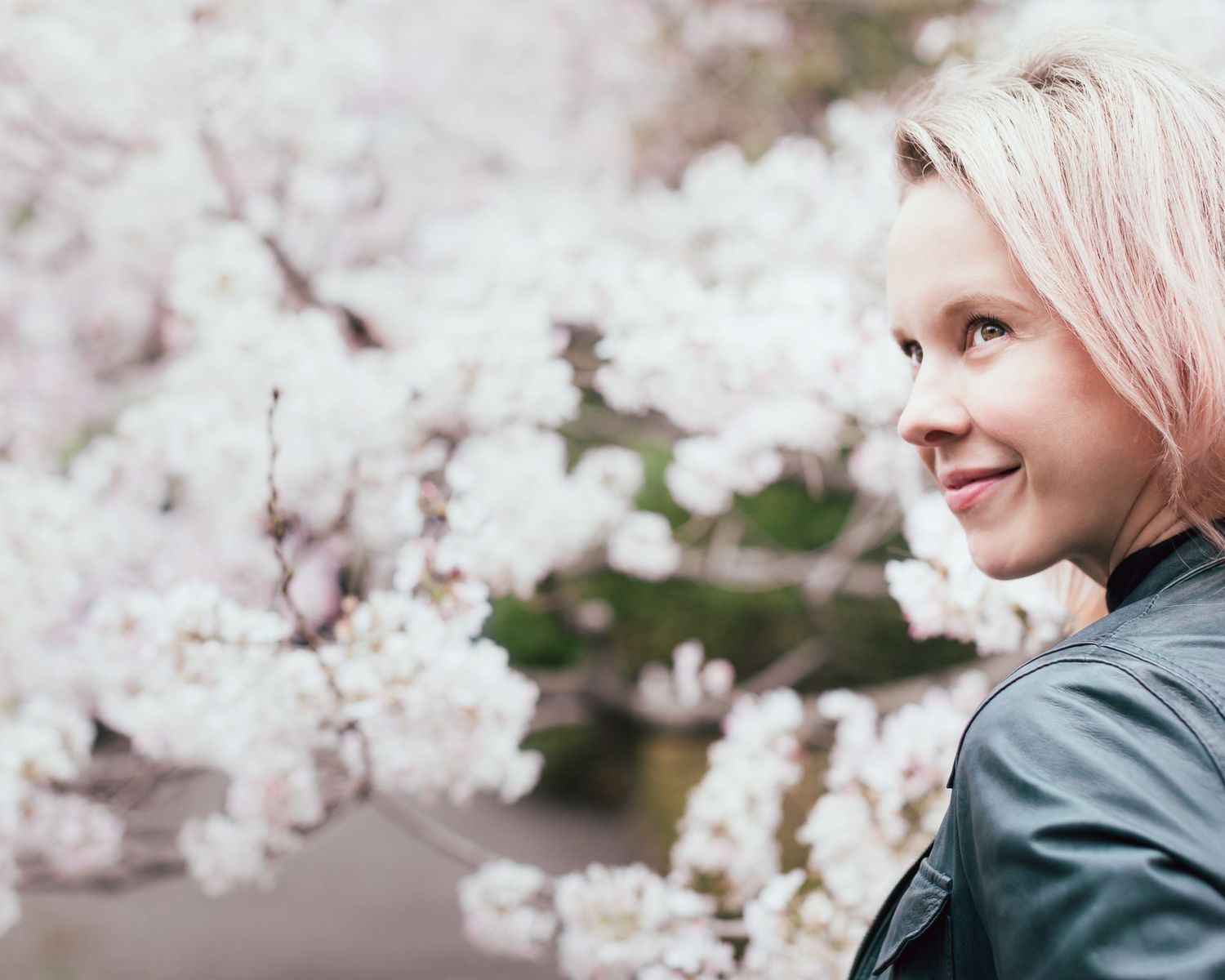 Artistic portrait series with soft focus cherry blossoms framing the composition.