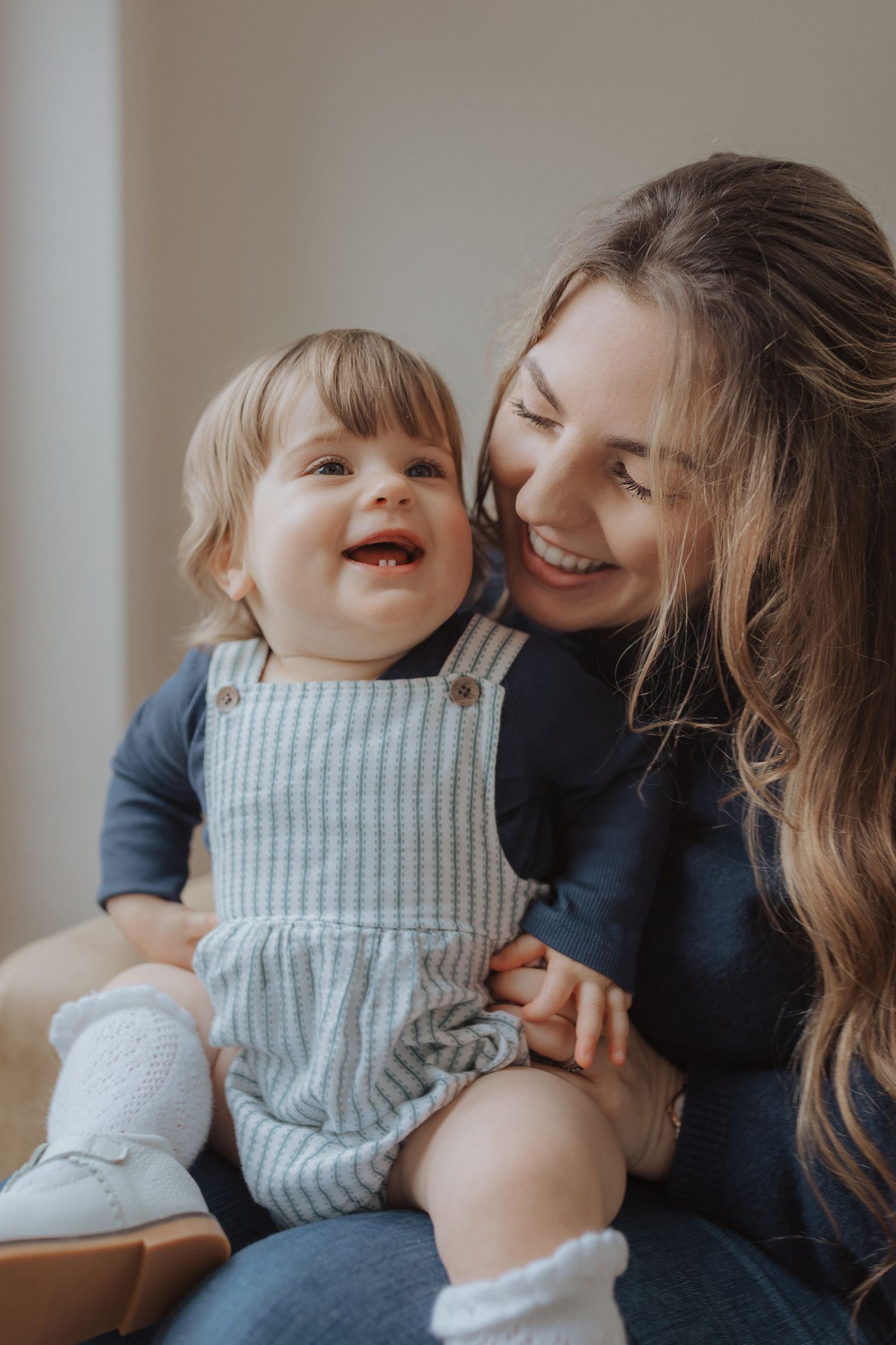 Parent and child sharing loving moments while sitting indoors.