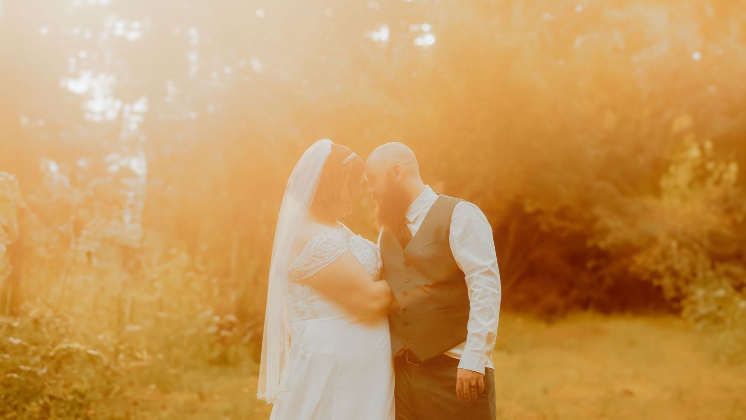 Romantic silhouettes against a warm orange sunset background in nature.
