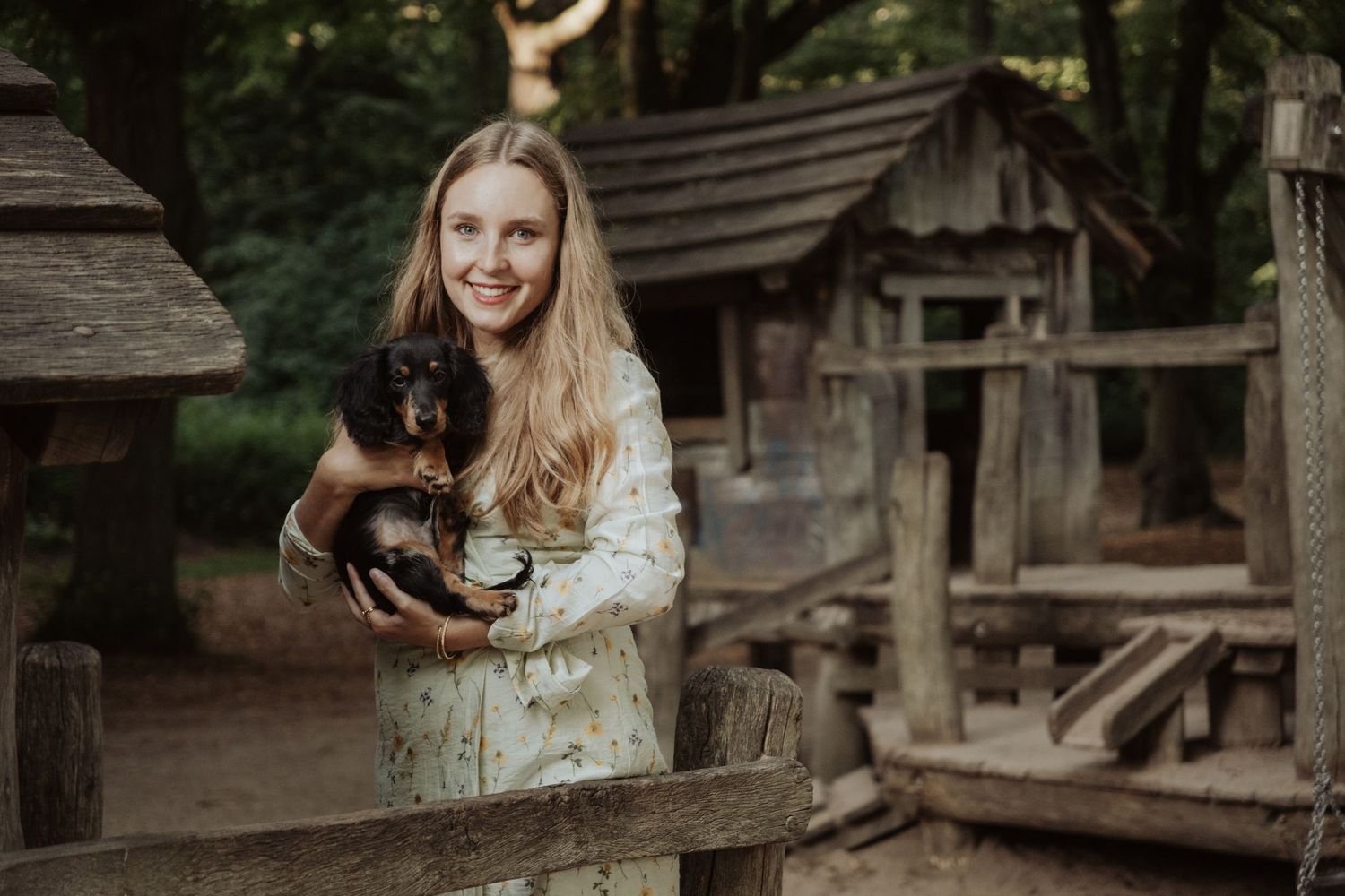 Fotoshooting von einem hübschen Mädchen mit ihrem Hund draußen in einem Wald vor einem Ferienhaus in Köln, Deutschland
