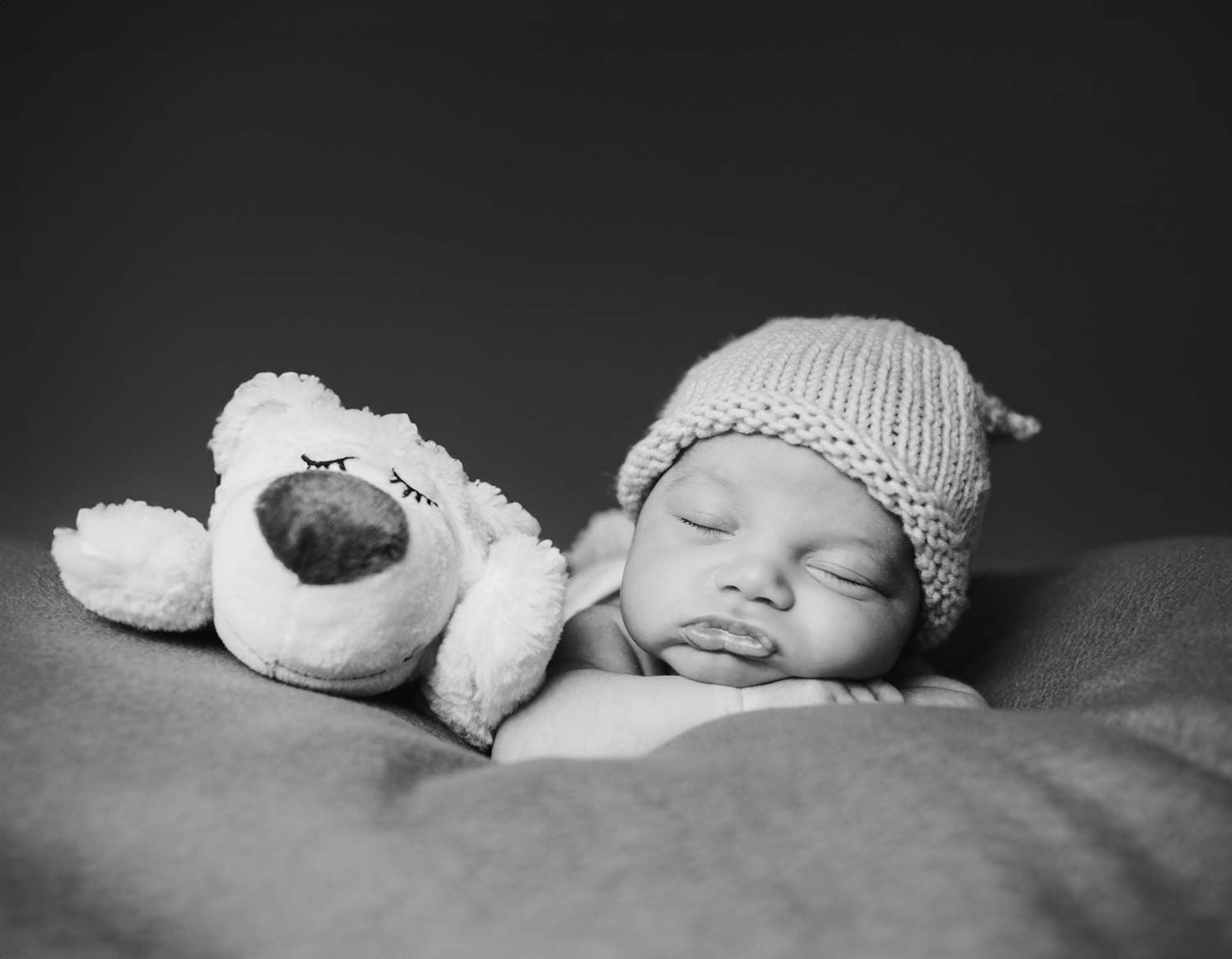ein Baby mit ihr Puppe schlaffen zusammen in einem Baby Fotoshooting bei dem Kunden zuhause, in Köln Stadt.