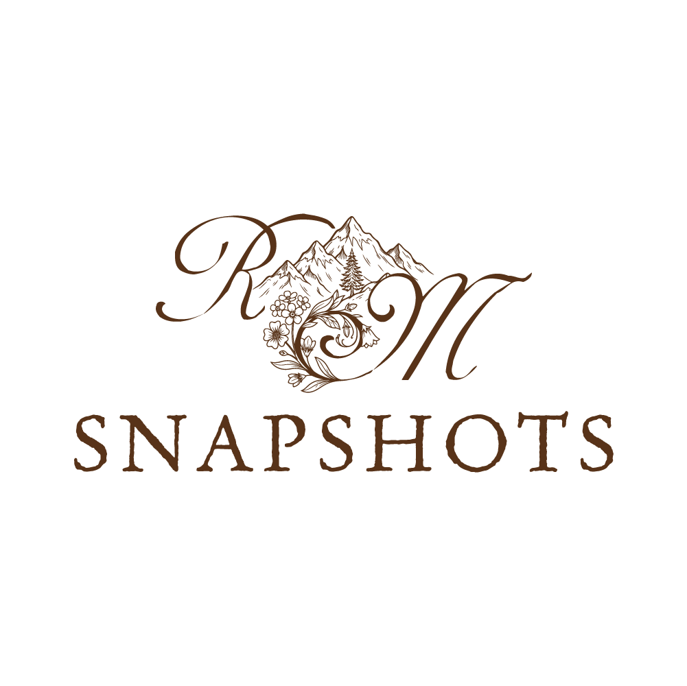 RM Snapshots logo with ornate brown monogram letters R and M, floral flourishes, and a mountain illustration above the word SNAPSHOTS.