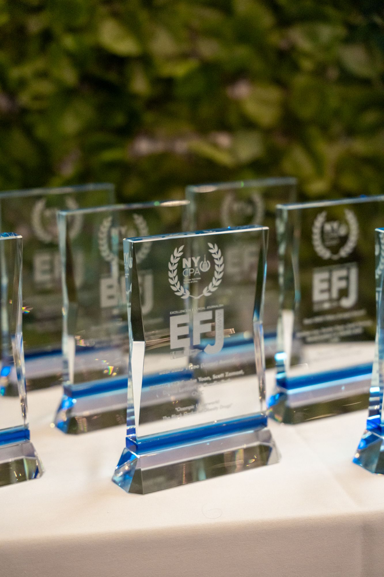 Row of crystal awards displayed on white surface with blue accents.