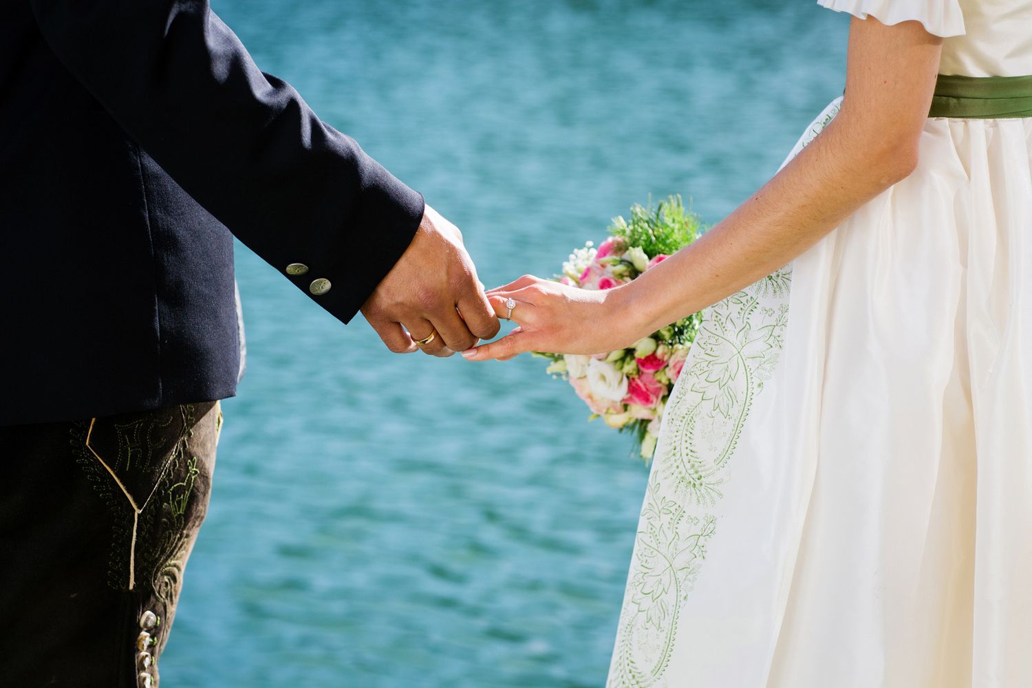 Hochzeitspaar am Wörthersee, blaues Wasser, Ringe, Brautstrauss